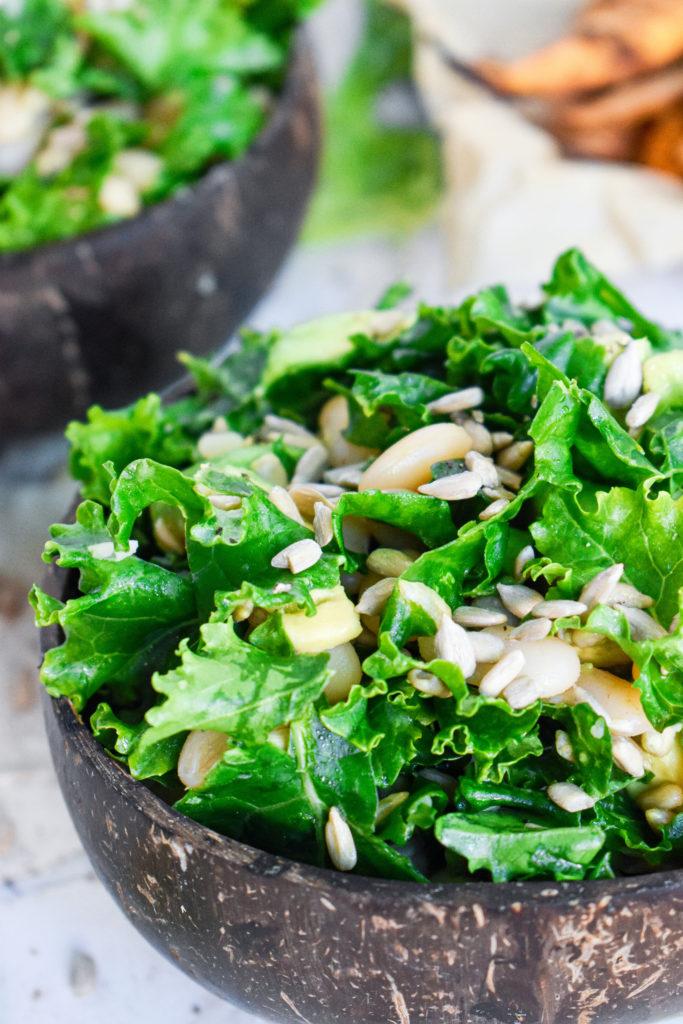 close up of the lemon kale salad showing the sunflower seeds, avocado, kale, and beans