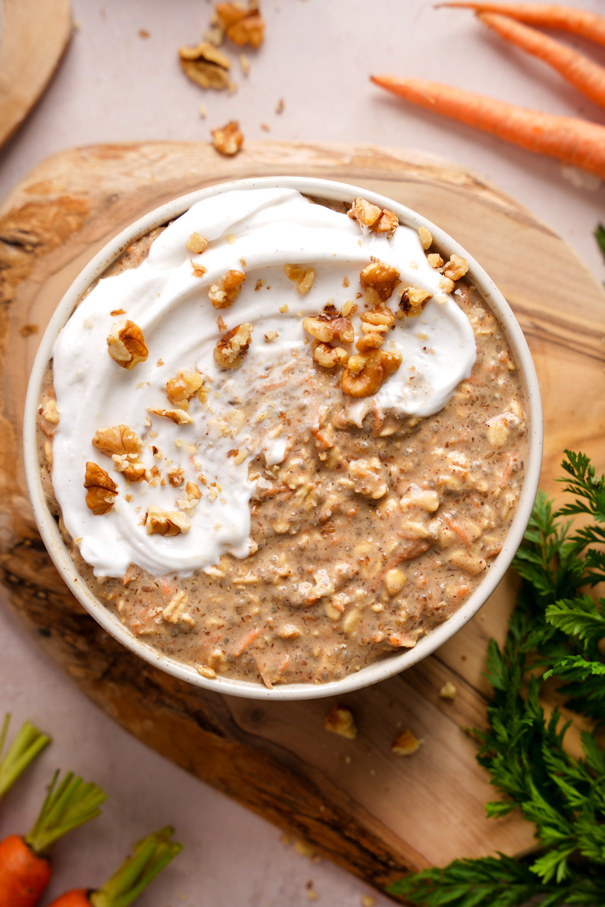 a bowl of the carrot cake overnight oats topped with coconut yogurt and walnuts
