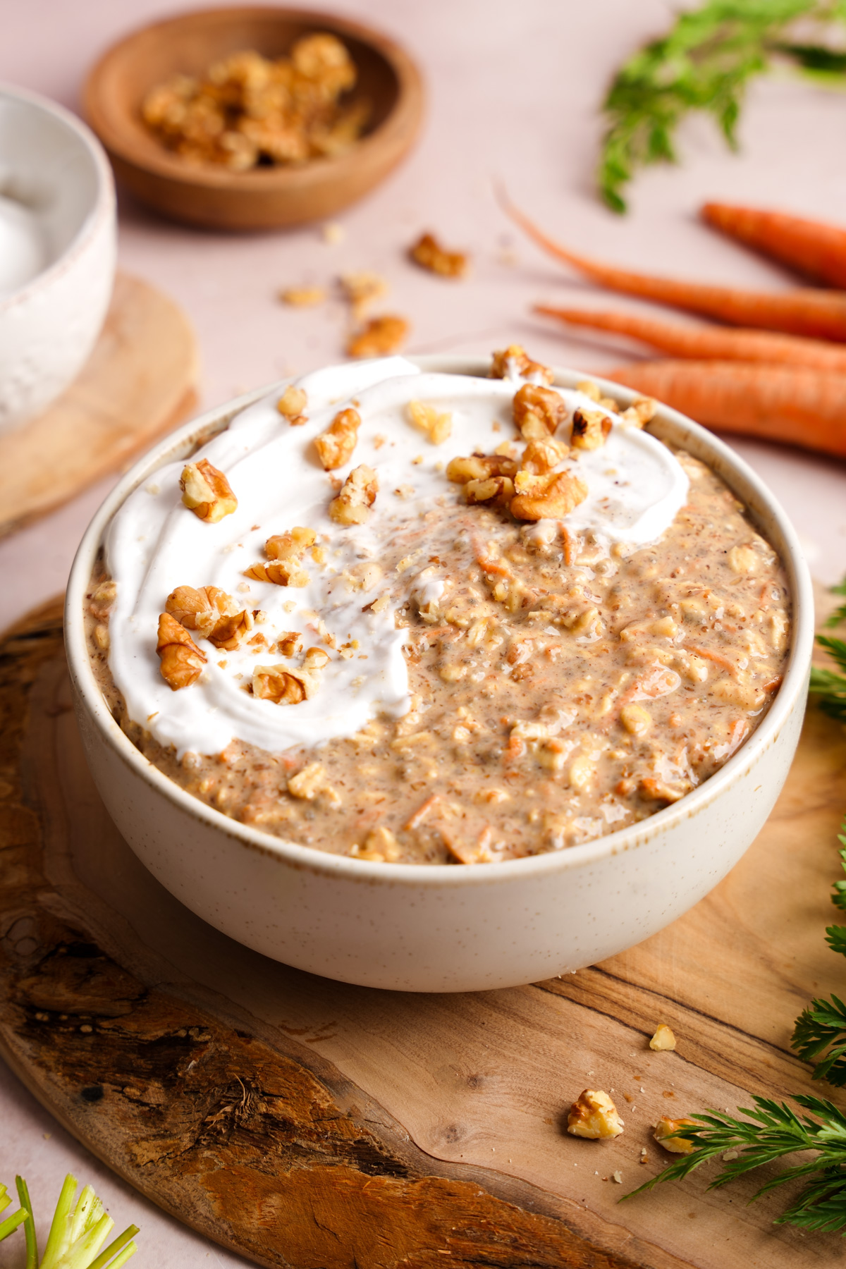 a bowl of the carrot cake overnight oats topped with fresh walnuts and coconut yogurt