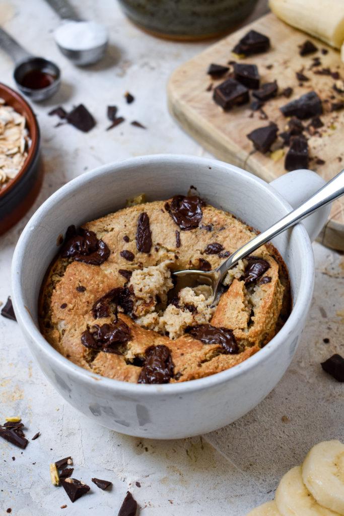 the banana baked oats with chocolate broken into to show the texture of this recipe