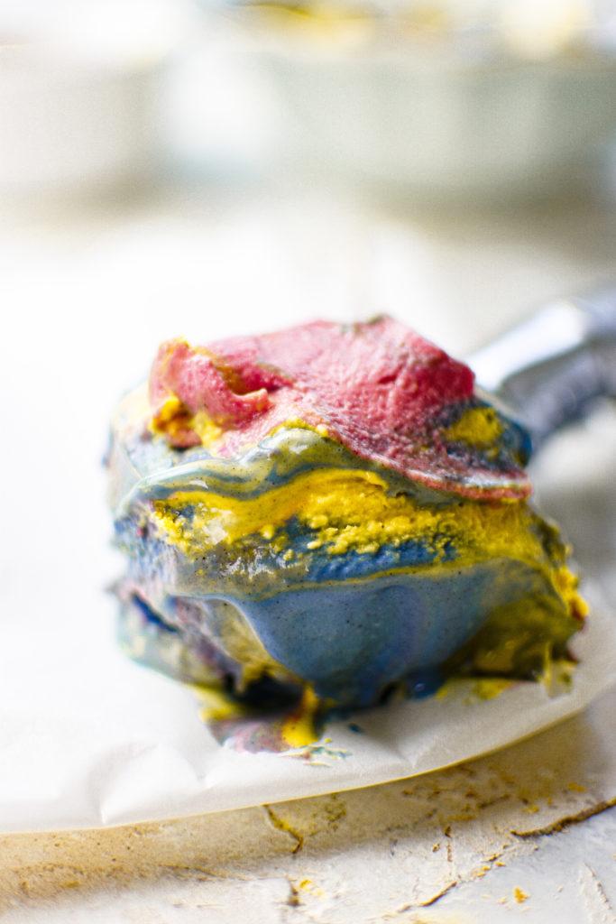 vegan superman ice cream on a spoon to show the creamy texture and colors