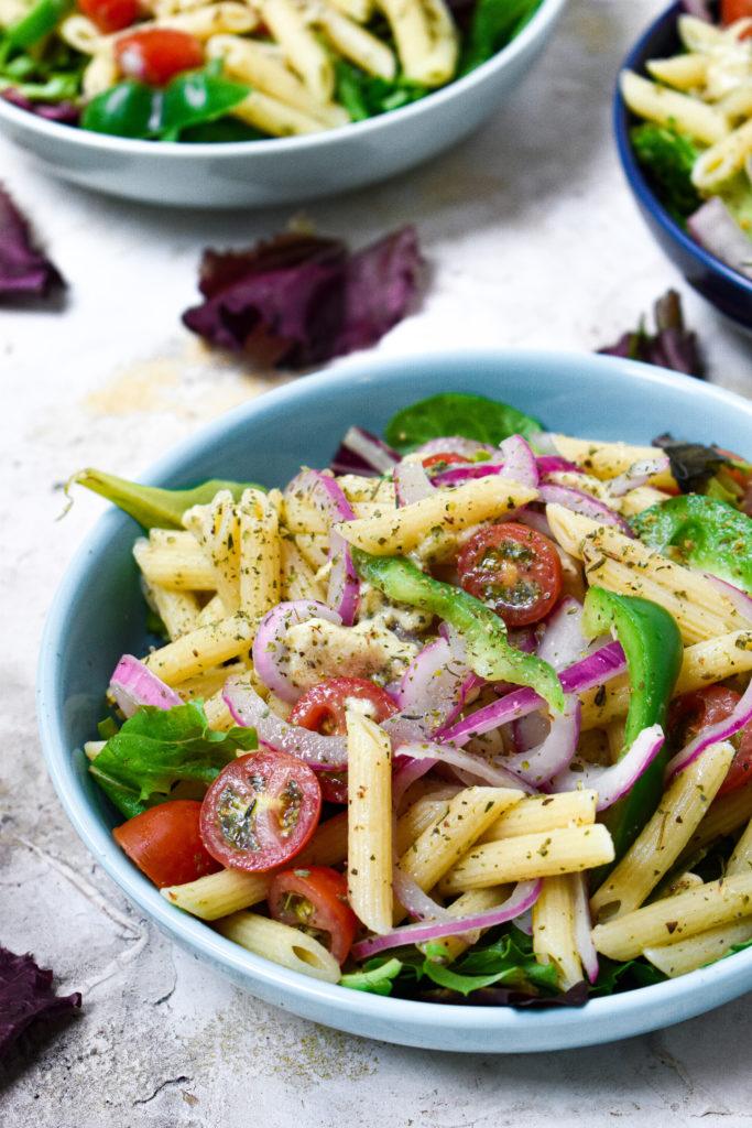 simple vegan pasta salad plated showcasing the fresh produce and vegan oil-free mozzarella