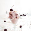 cherry almond ice cream in glass ice cream cup with fresh cherries