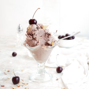 cherry almond ice cream with fresh cherries surrounding the ice cream cup
