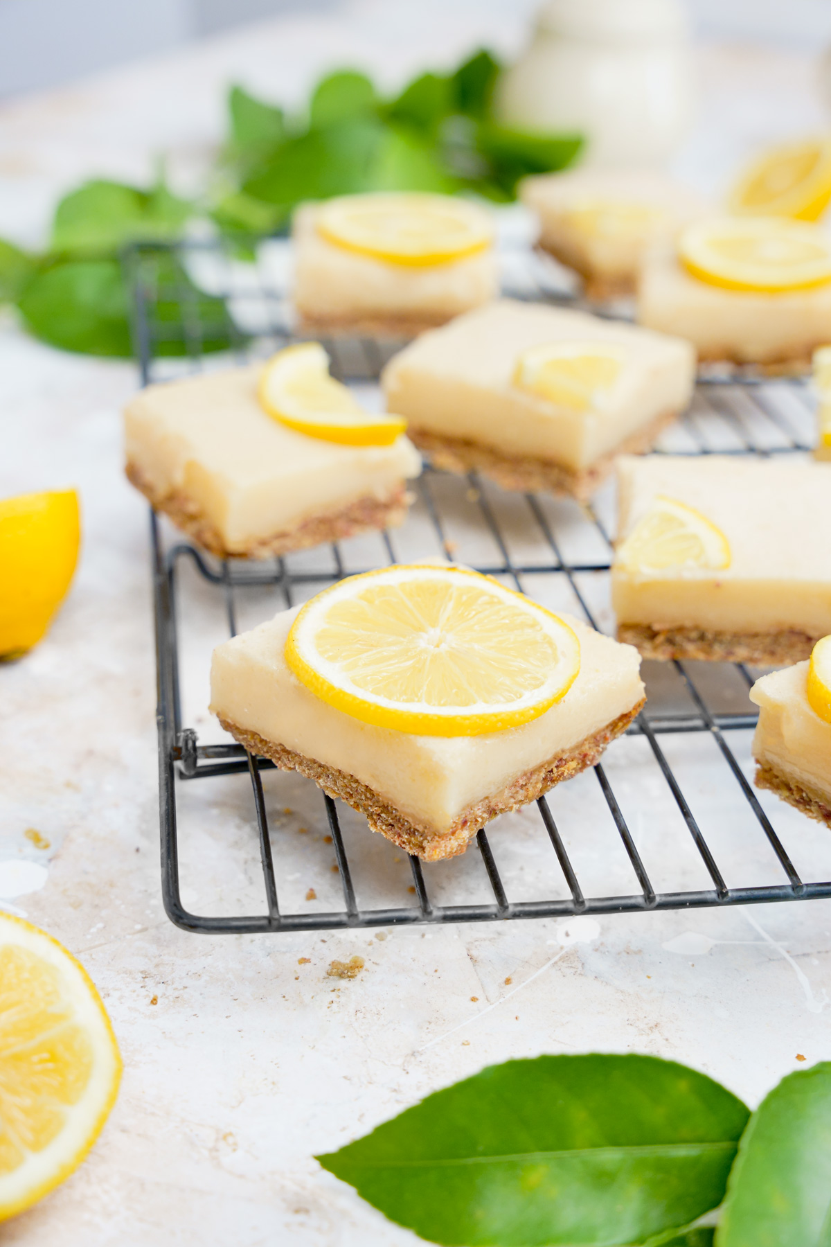 creamy vegan lemon bars with different lemon shapes on top of the individually cut squares.