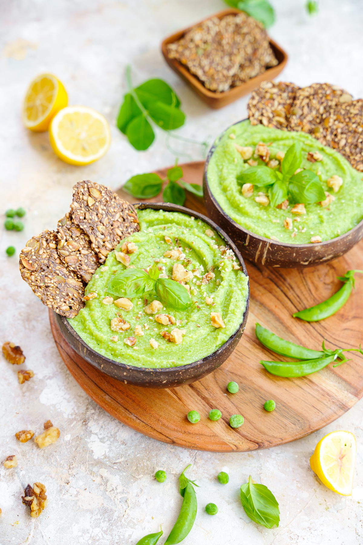 pea hummus with basil, crackers, and walnuts on top