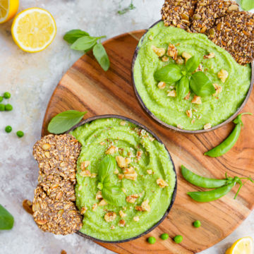 raw vegan pea soup with crackers and walnuts on top