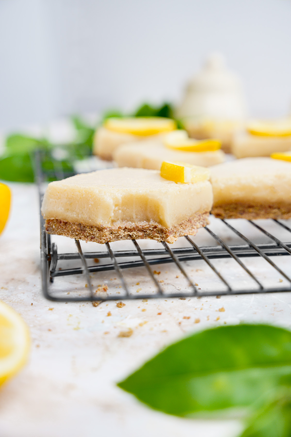the vegan lemon bars with a bite taken out of them to show the firm gooey texture.
