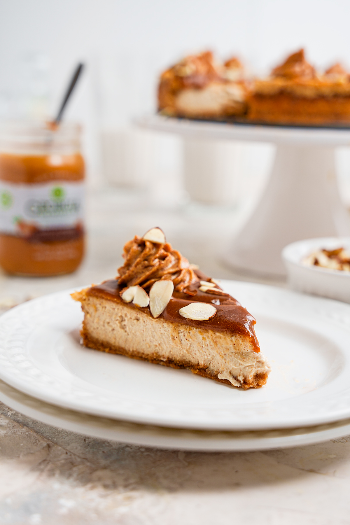 a slice of the maple almond caramel cheesecake to show the creamy texture and gooey caramel topping