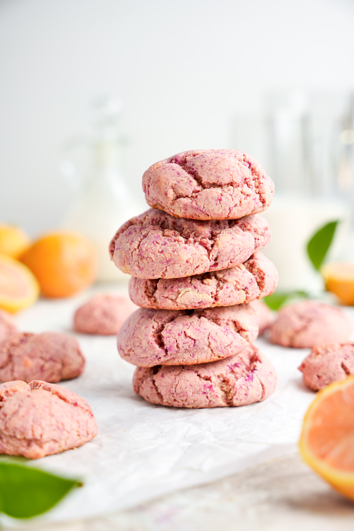 the pink vegan lemon crinkle cookies stacked on top of each other 