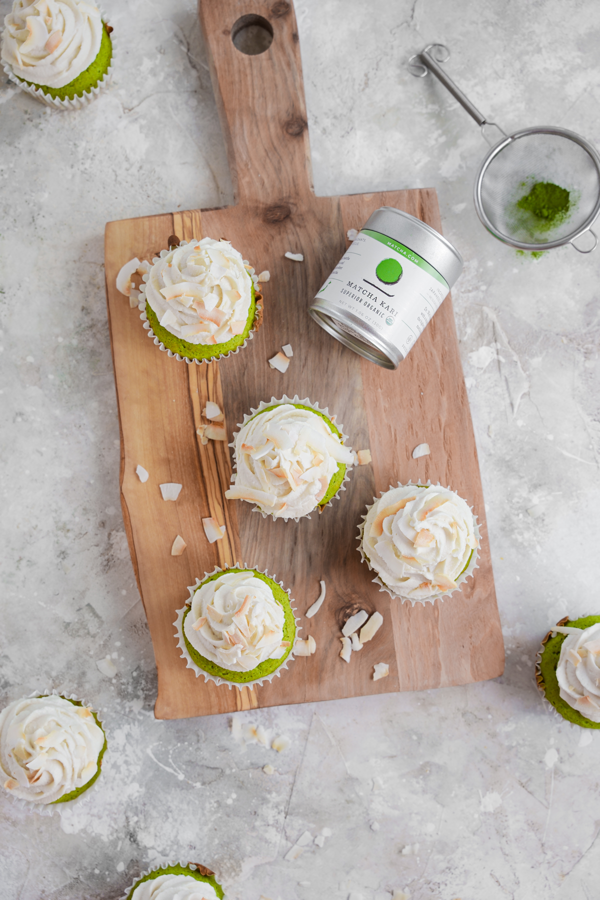 looking down at the matcha cupcakes on a wooden platter and the matcha.com superior organic tin