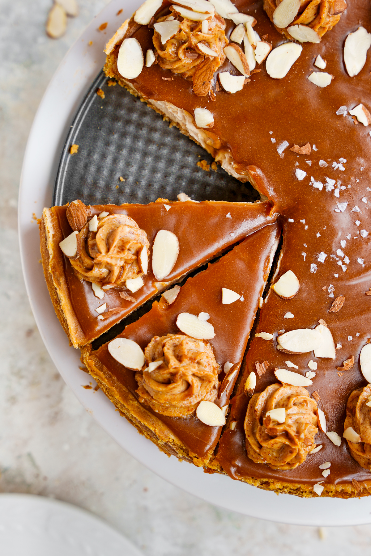 Close up of the vegan caramel cheesecake to show the caramel top and almond piped frosting