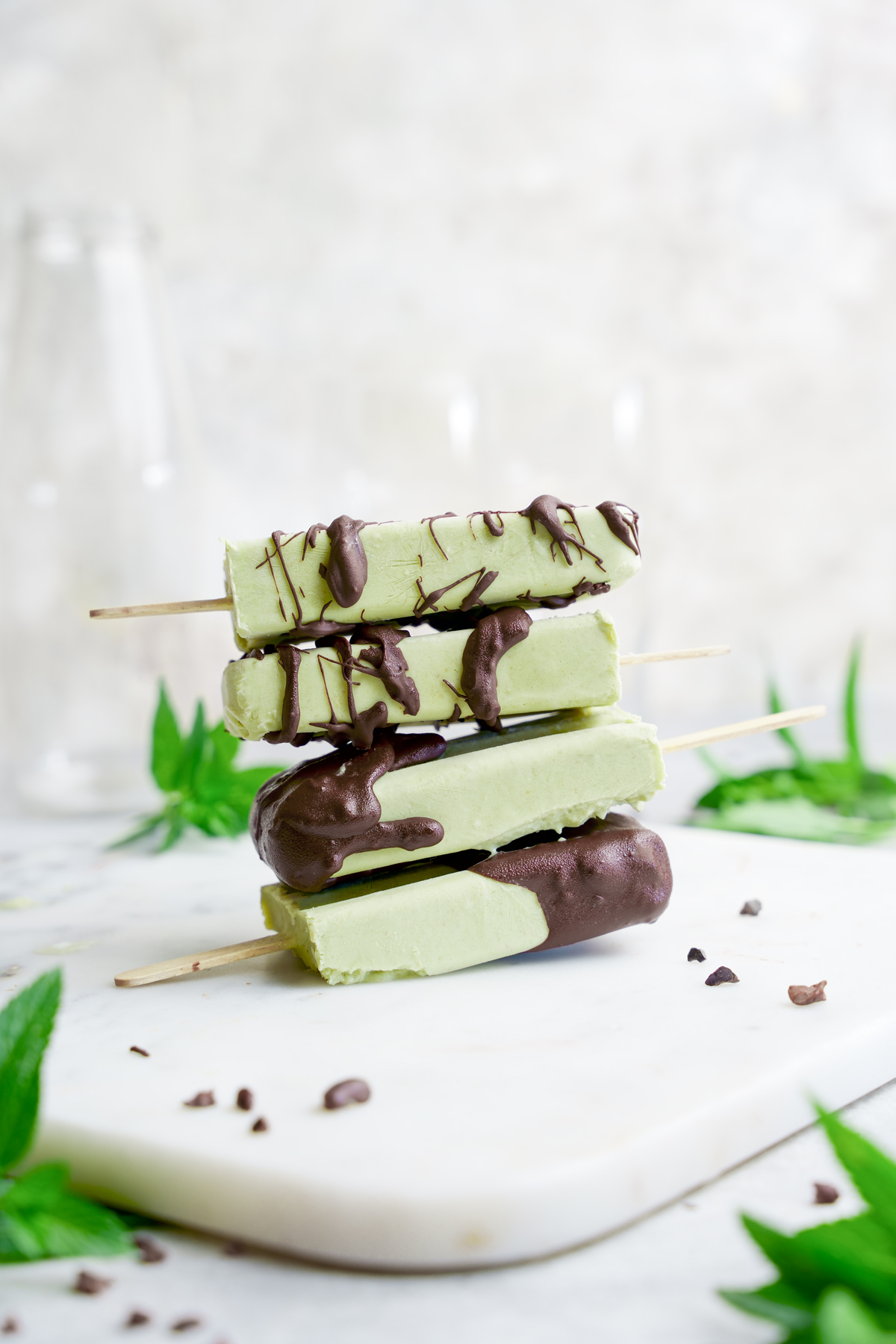 the matcha popsicles stacked on top of each other and drizzled with chocolate 