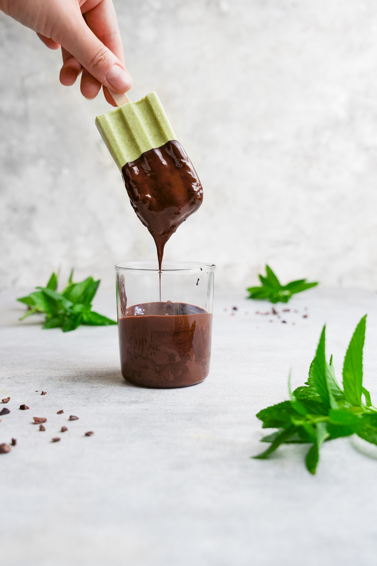 dipping the mint chocolate chip popsicle into vegan dark chocolate 