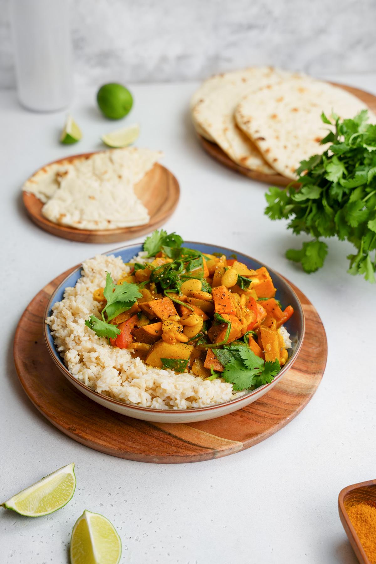 the butter bean curry over rice with pita bread and fresh cilantro and limes