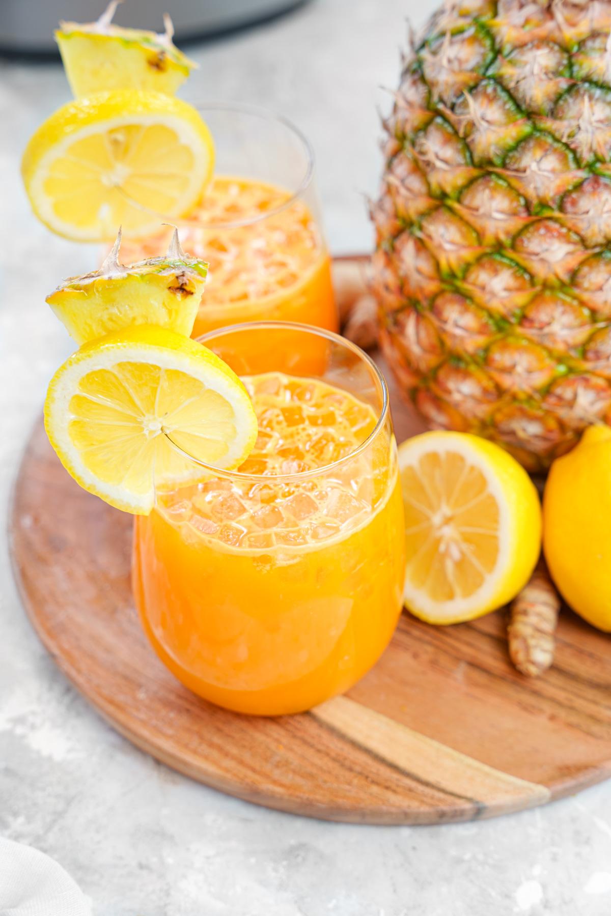 close up of the cold pressed turmeric juice with all the ingredients around it