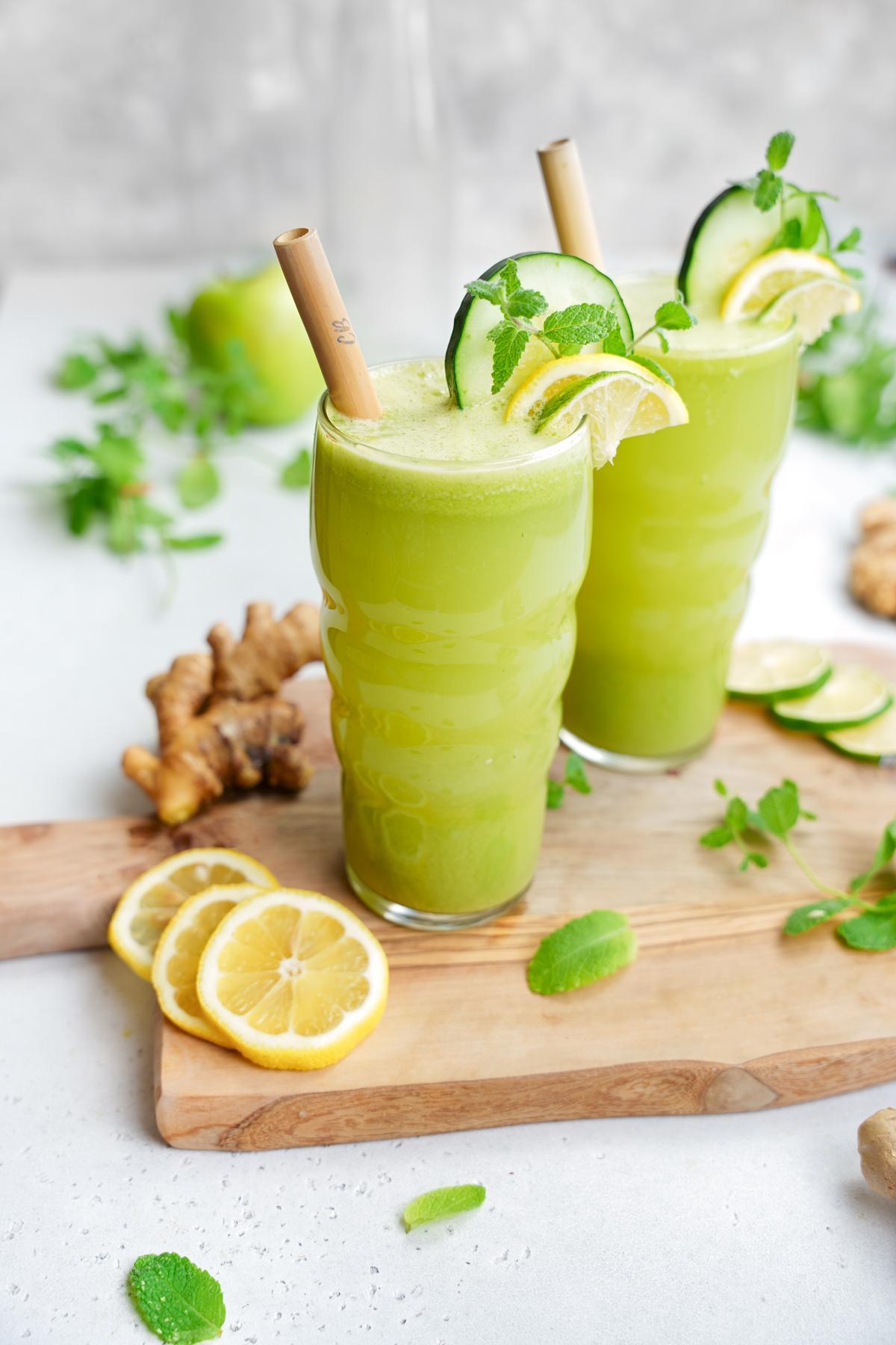 the glasses with ginger, mint, lemon, and limes surrounding it