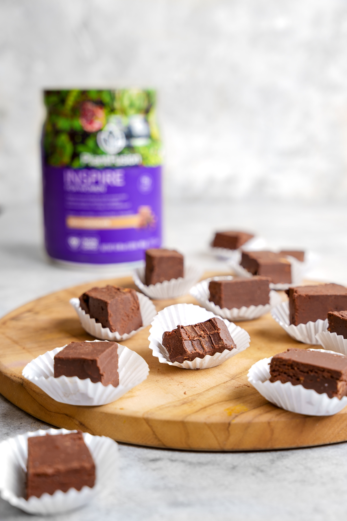 the protein fudge laying on a plate with the plantfusion inspire for women in the back
