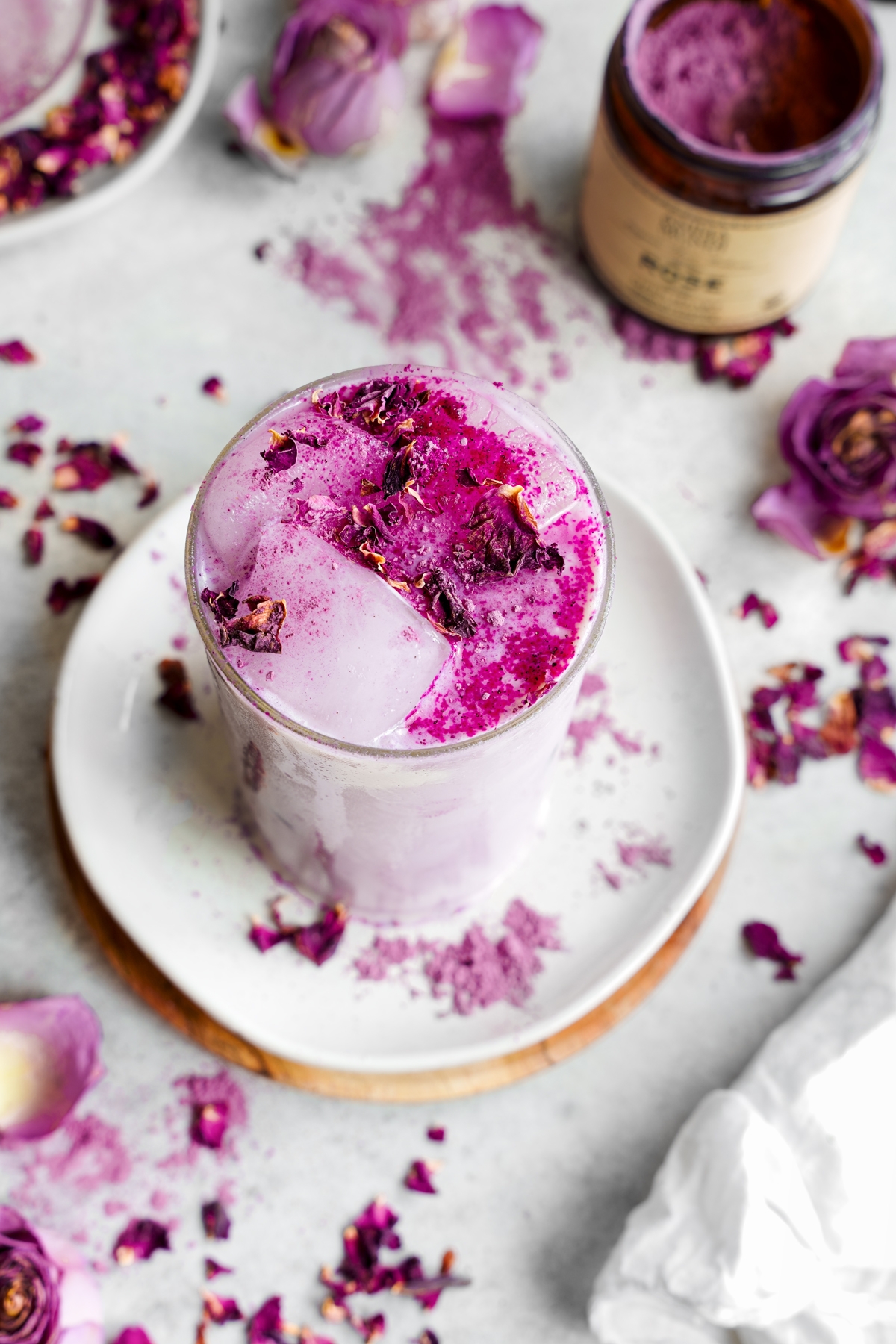 rose latte with fresh rose petals around and extra rose powder on top