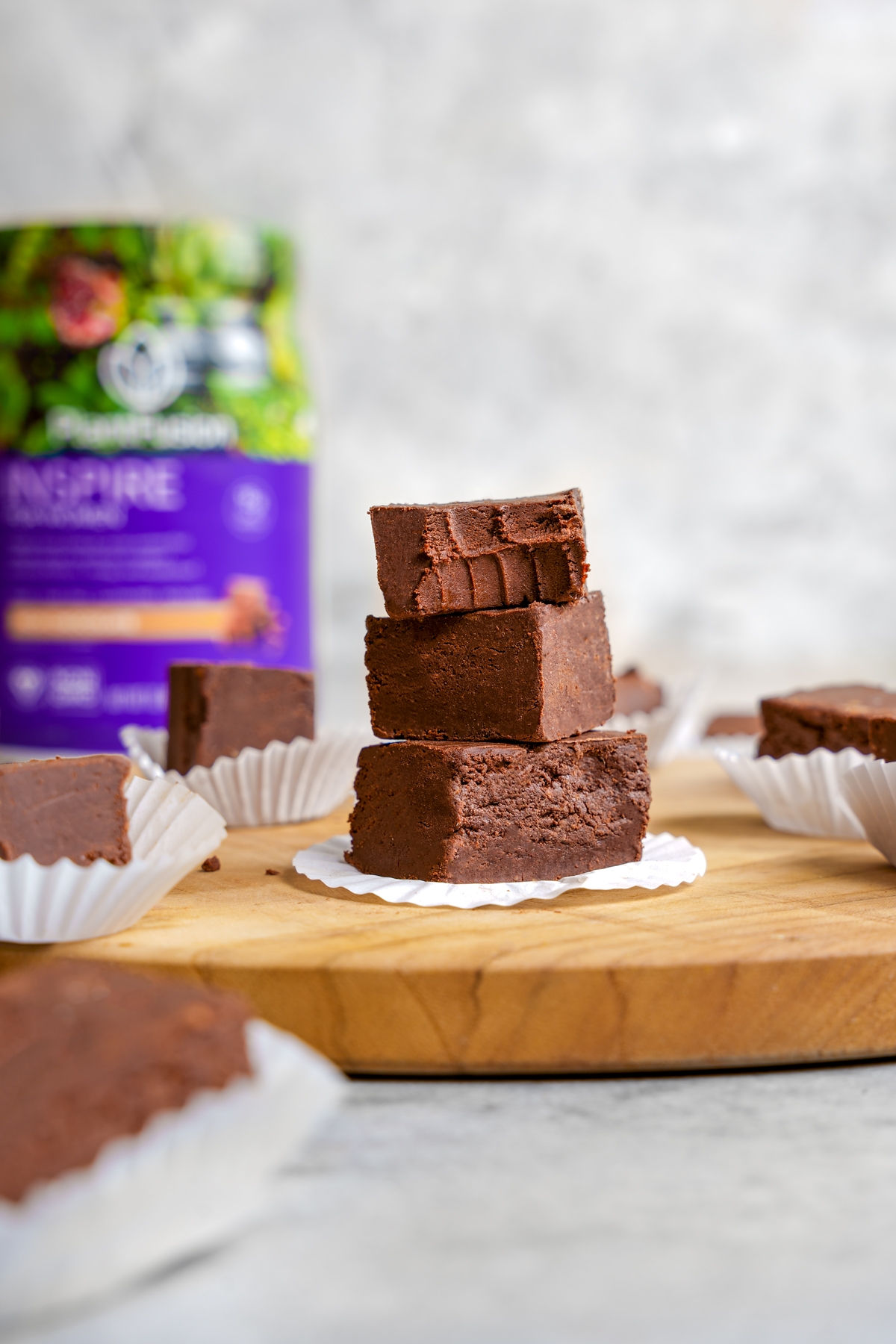 the vegan protein fudge stacked on top of each other with the plantfusion inspire for women in the back 