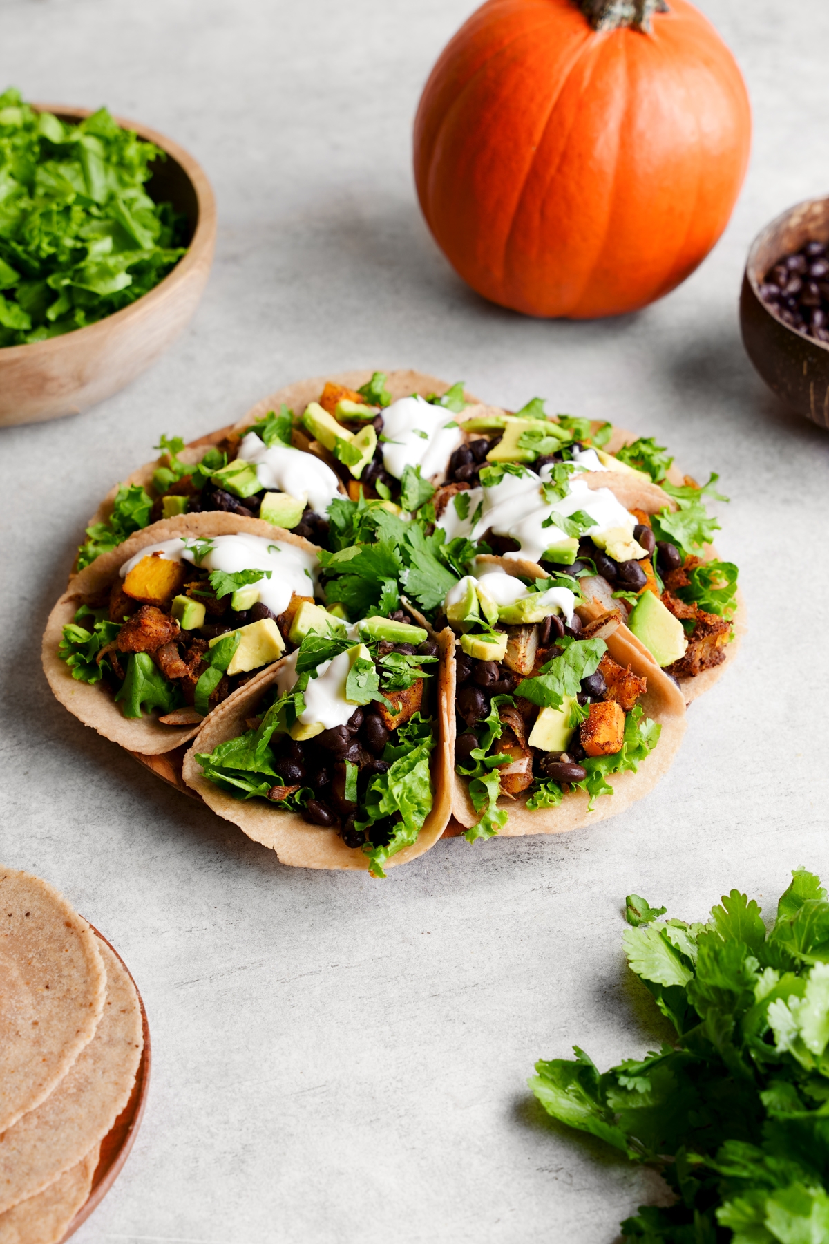 the pumpkin spice tacos on a plate toped with the fresh avocado, cilantro, and sour cream