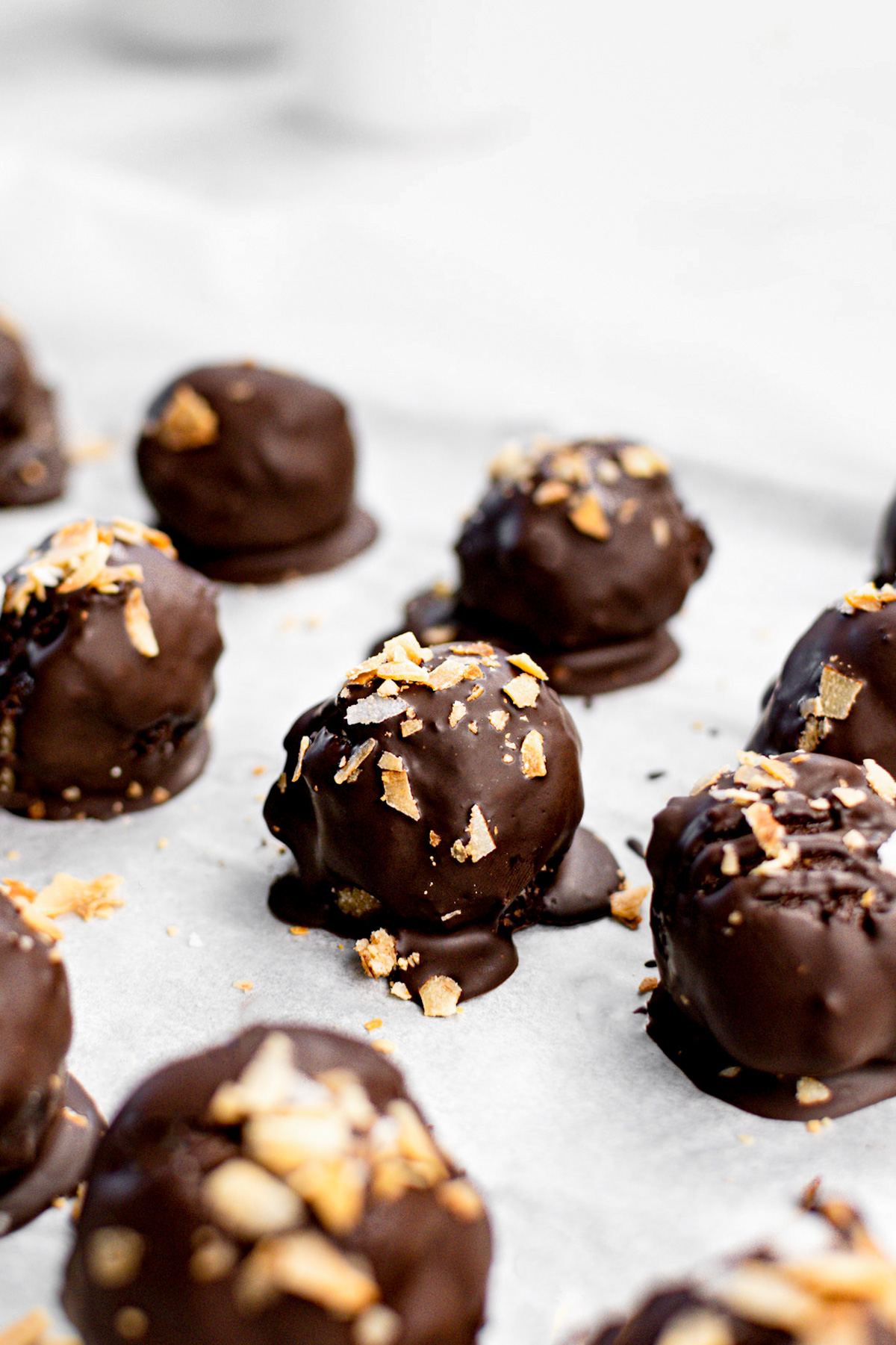 the samoa truffles lined up on a baking sheet with toasted coconut on top