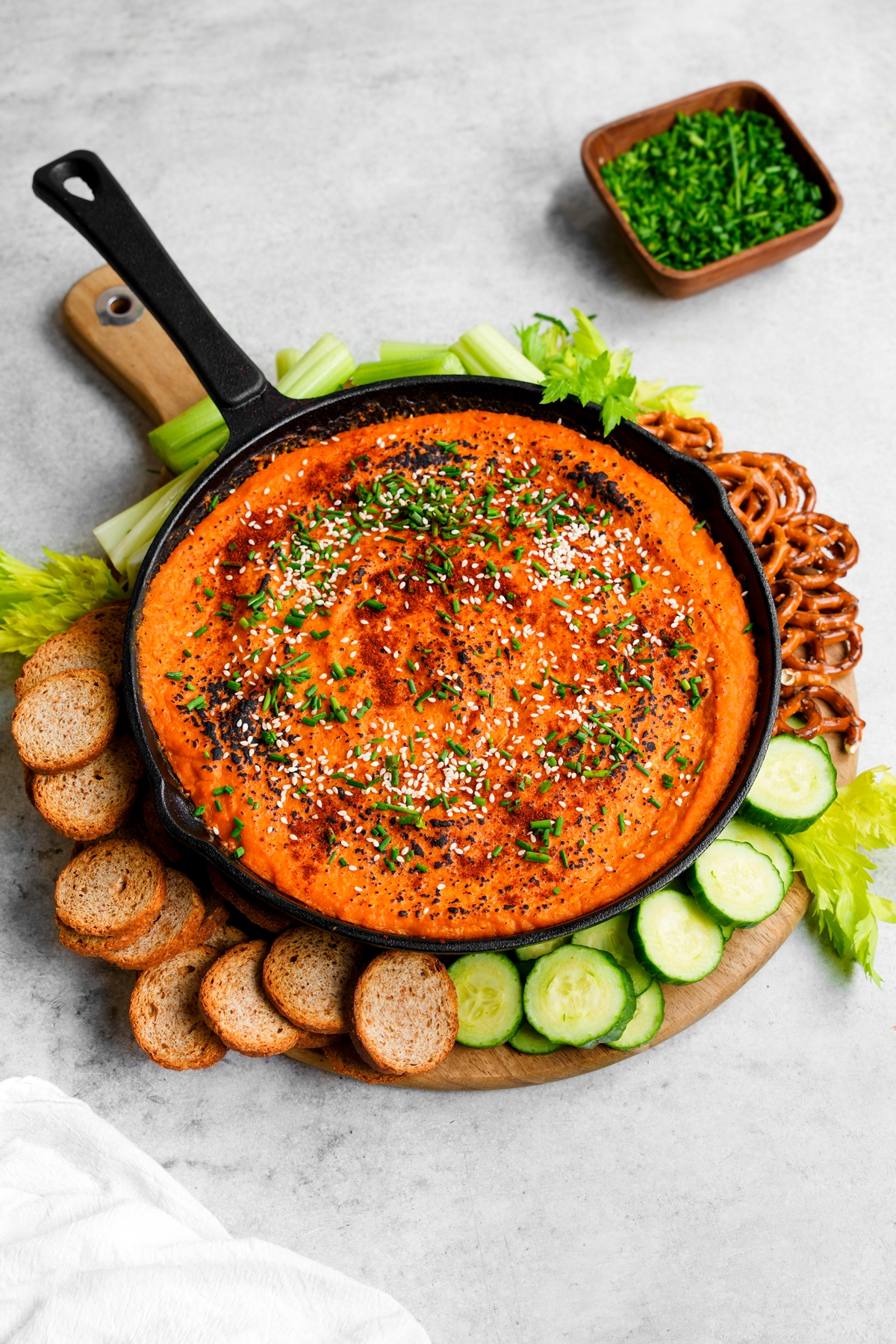 the butternut squash dip in a cast iron dish with dipping ingredients around it