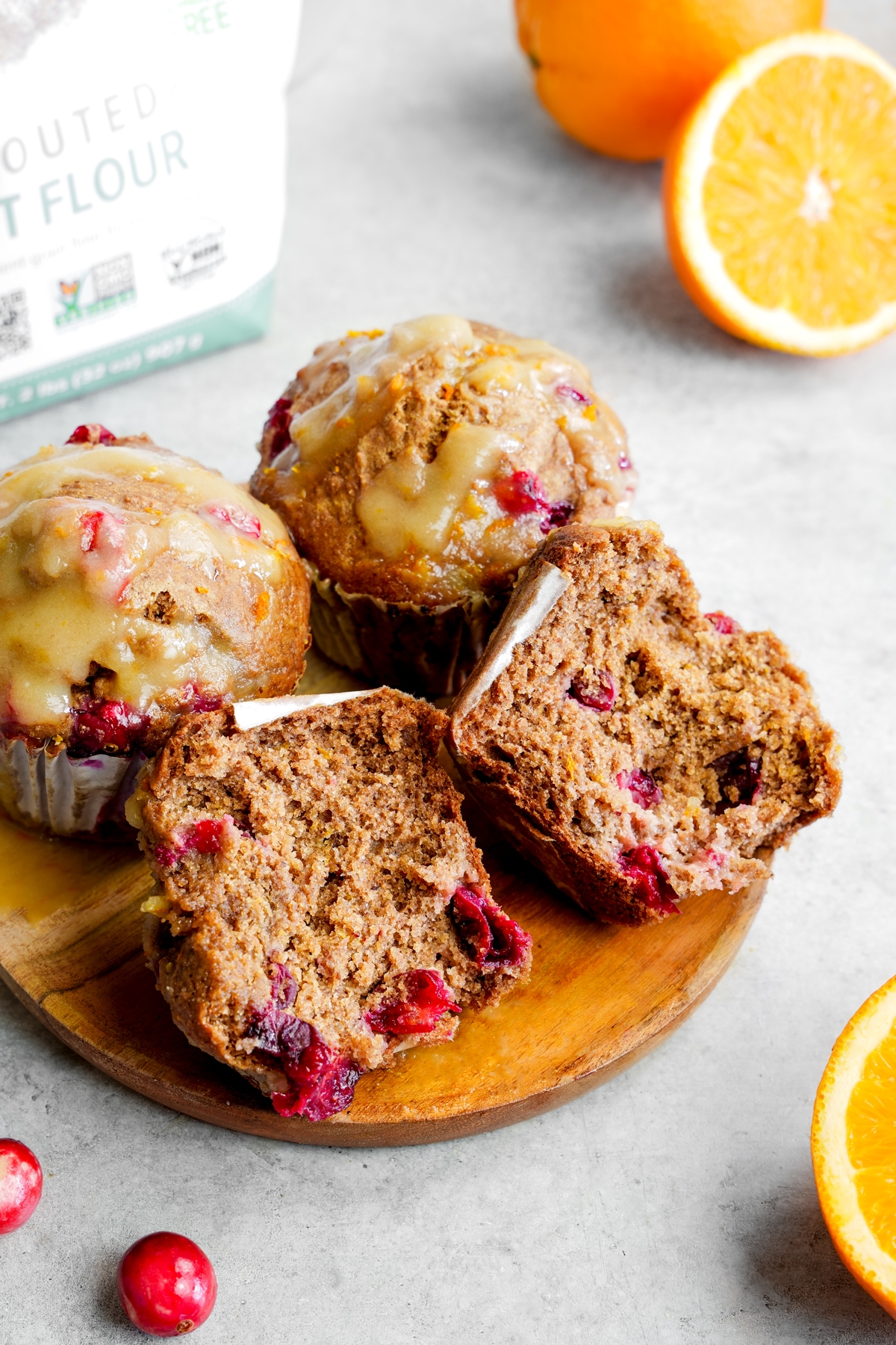 the vegan cranberry orange muffin split in half to show the fluffy texture of the muffins