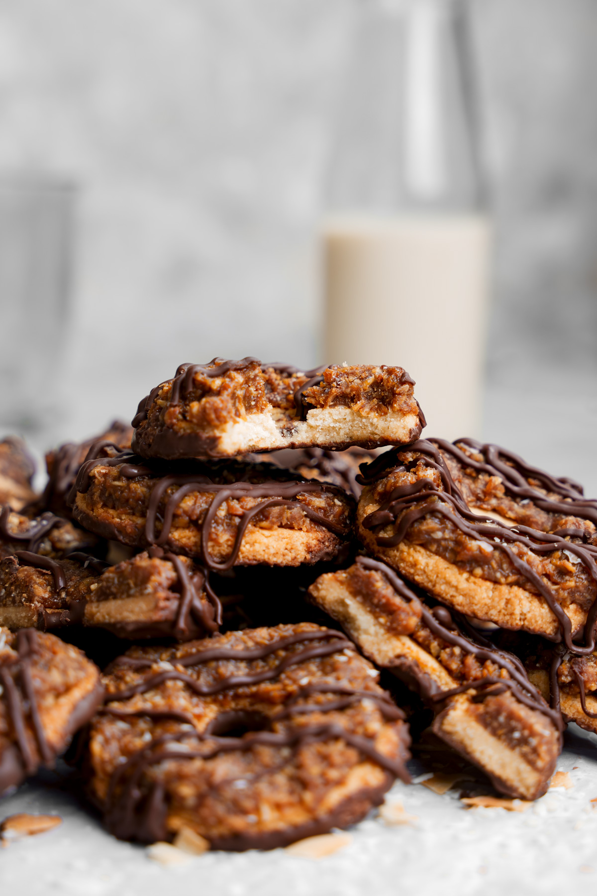 the gluten-free samoas stacked on top of each other with one with a bite taken out of it on top