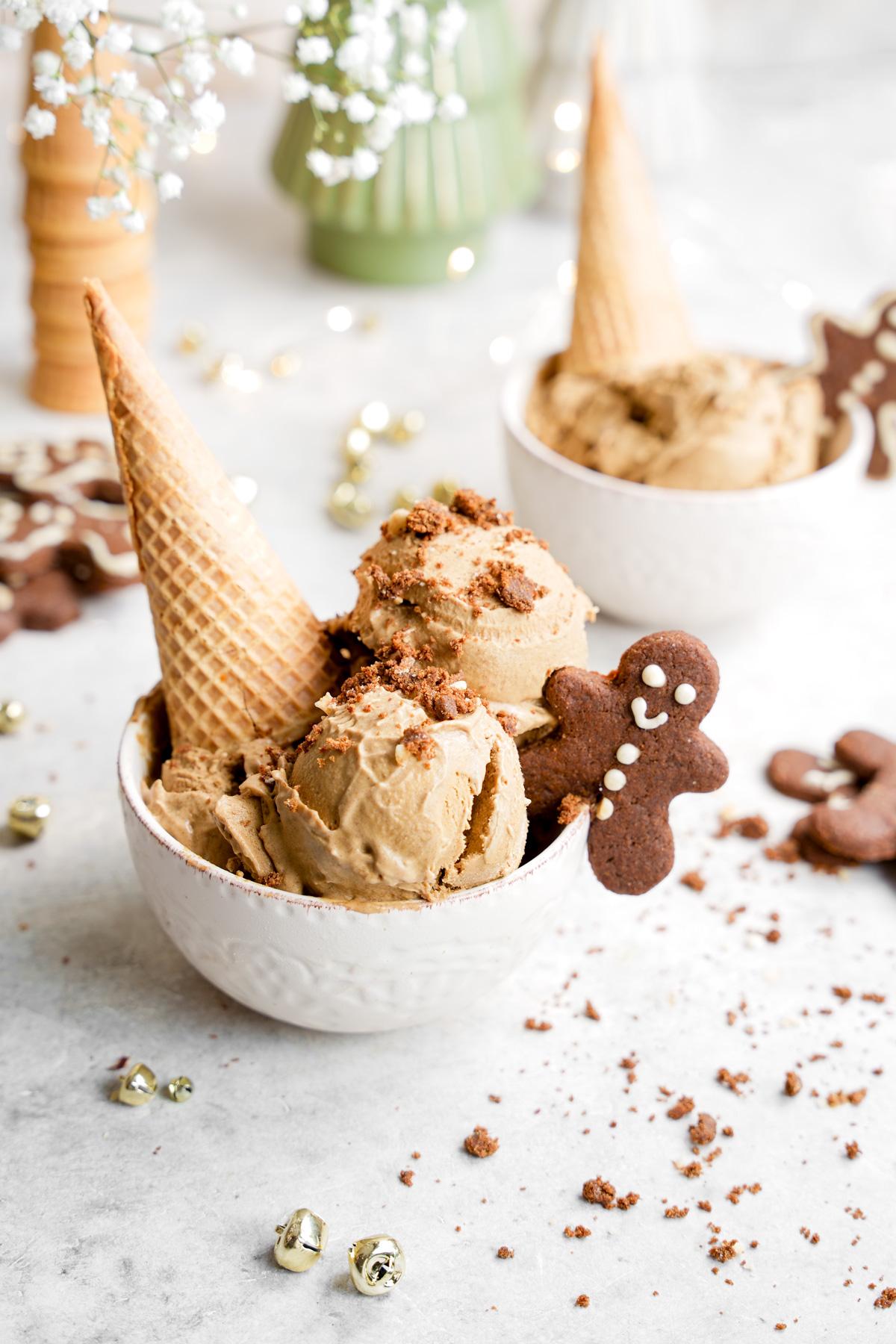 the gingerbread ice cream in a bowl with an ice cream cone and a gingerbread cookie