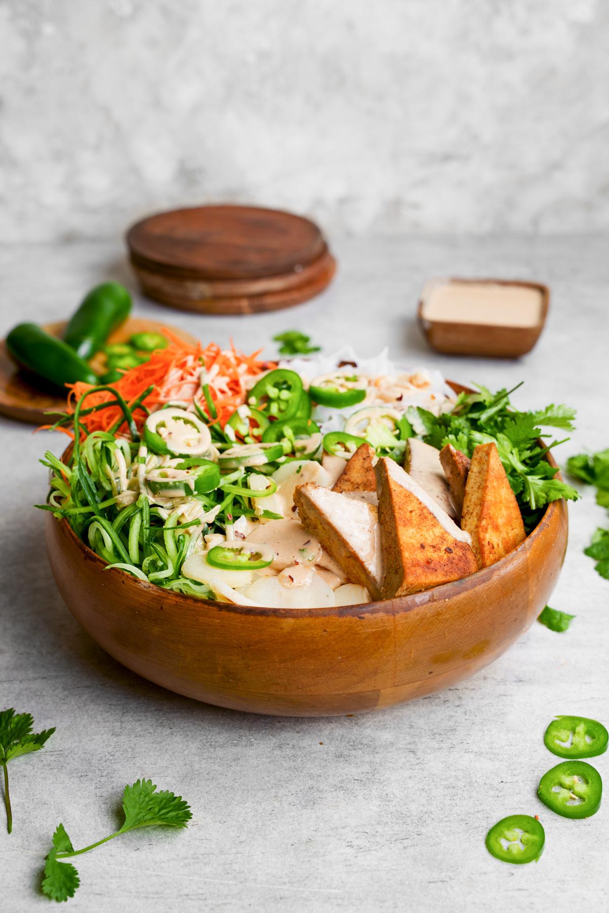the banh mi noodles in a large bowl with fresh ingredients all around