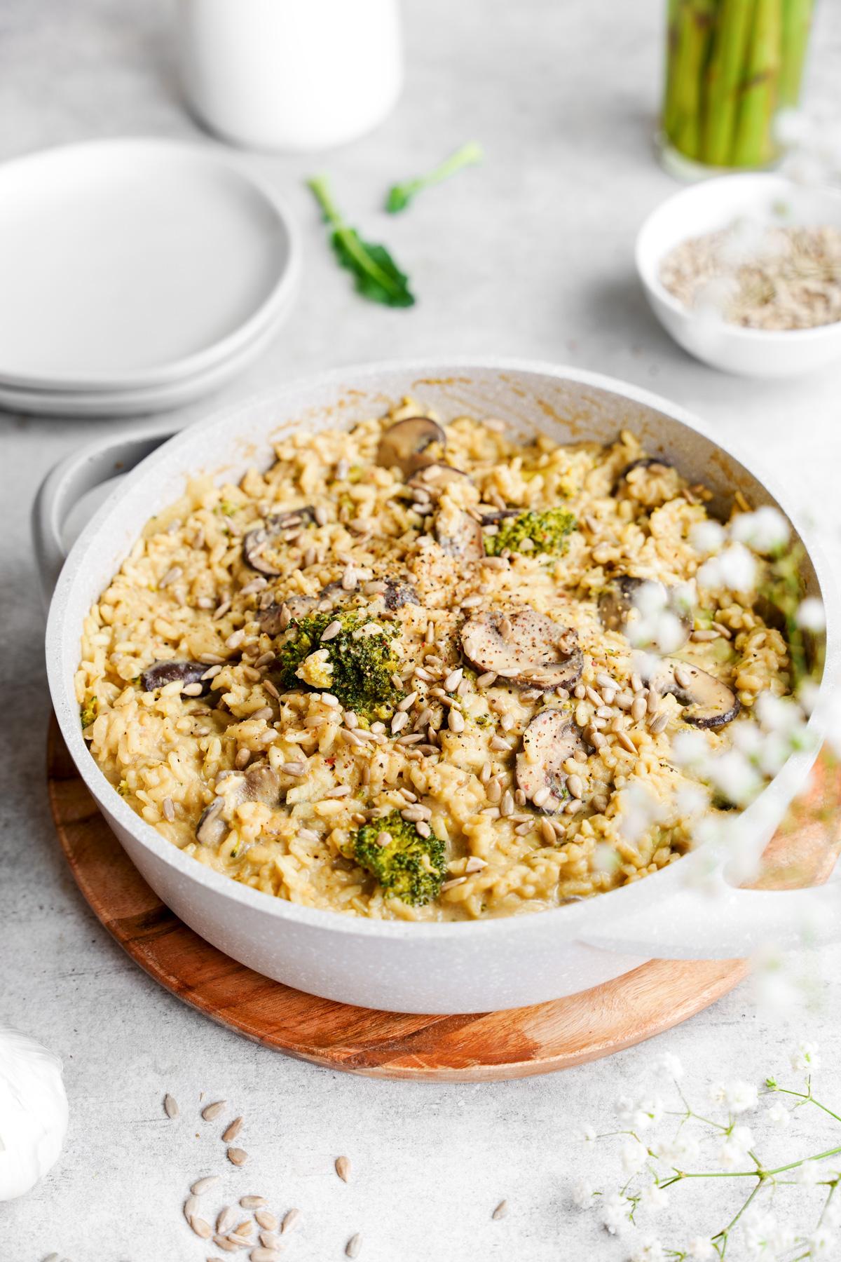 the creamy sunflower seed risotto in a bowl with the mushrooms and broccoli