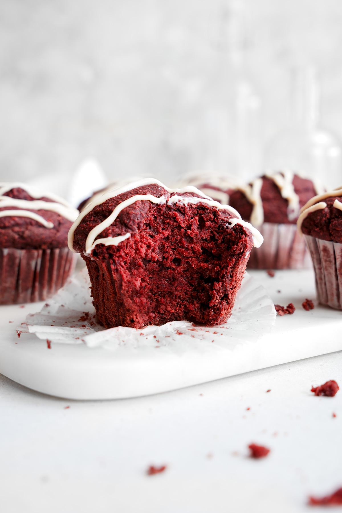 the red velvet muffins with a bite taken out of one standing up