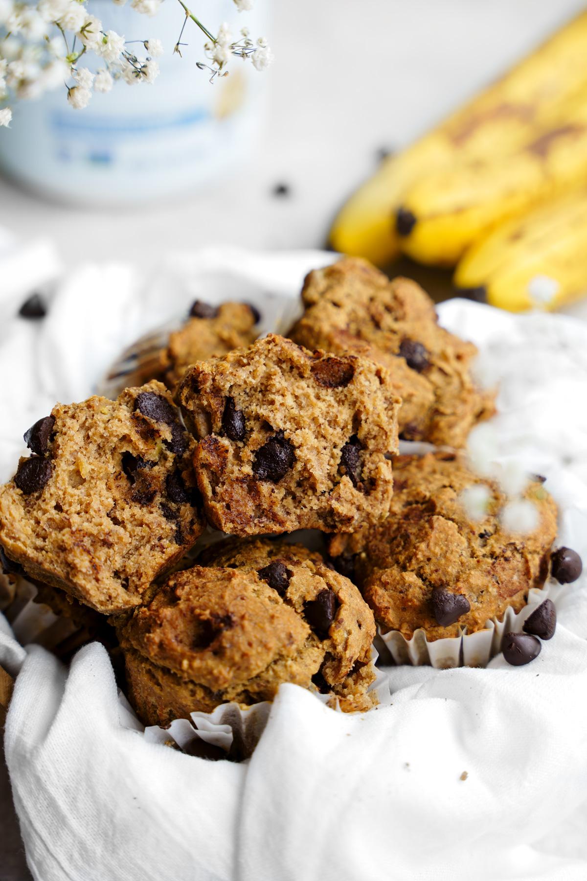 the vegan banana chocolate chip protein muffins broken in half to show the fluffy and moist texture