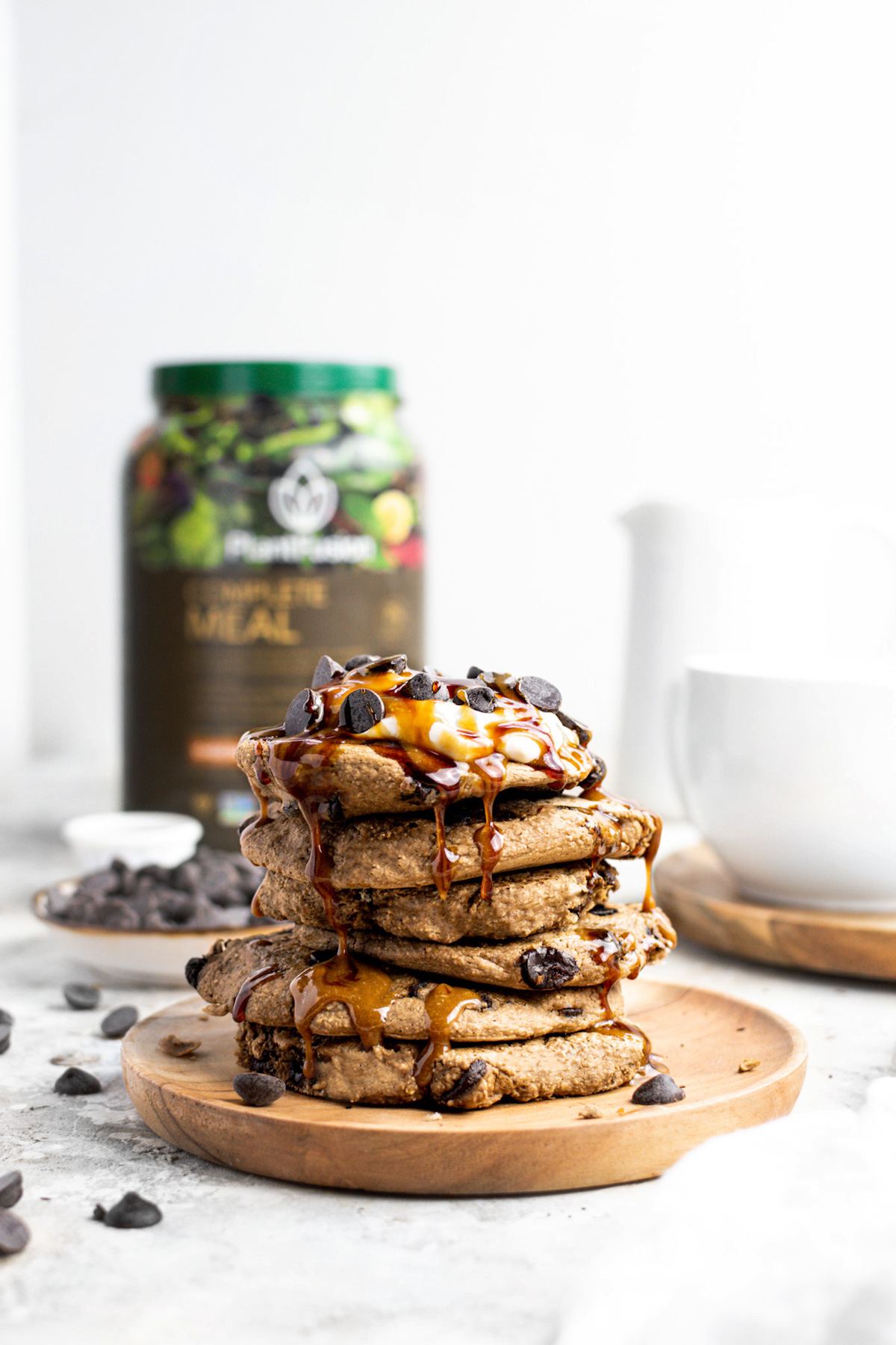 The chocolate protein pancakes stacked on top oof each other with caramel and chocolate dripping down the pancakes