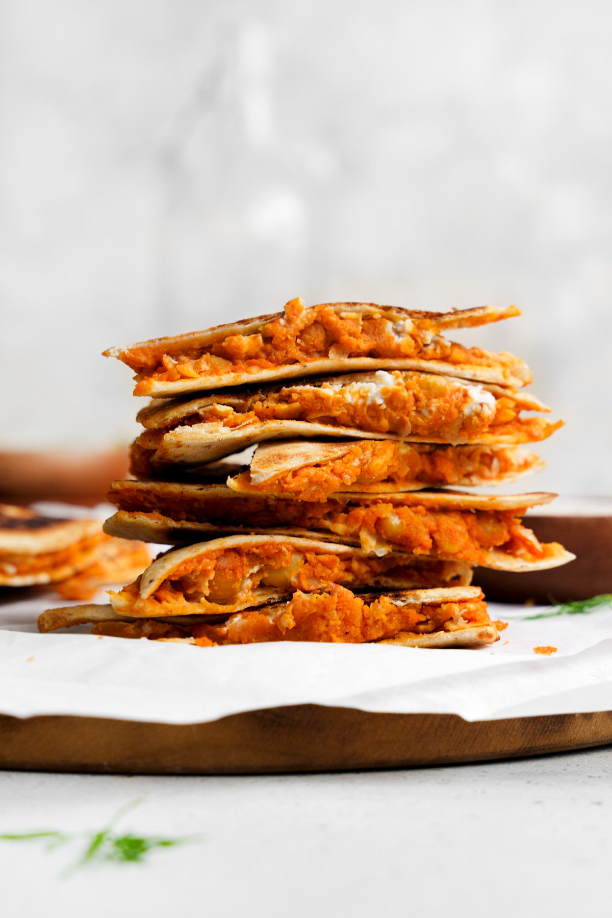 the vegan buffalo chickpea quesadillas stacked on top of each other with the filling spilling out