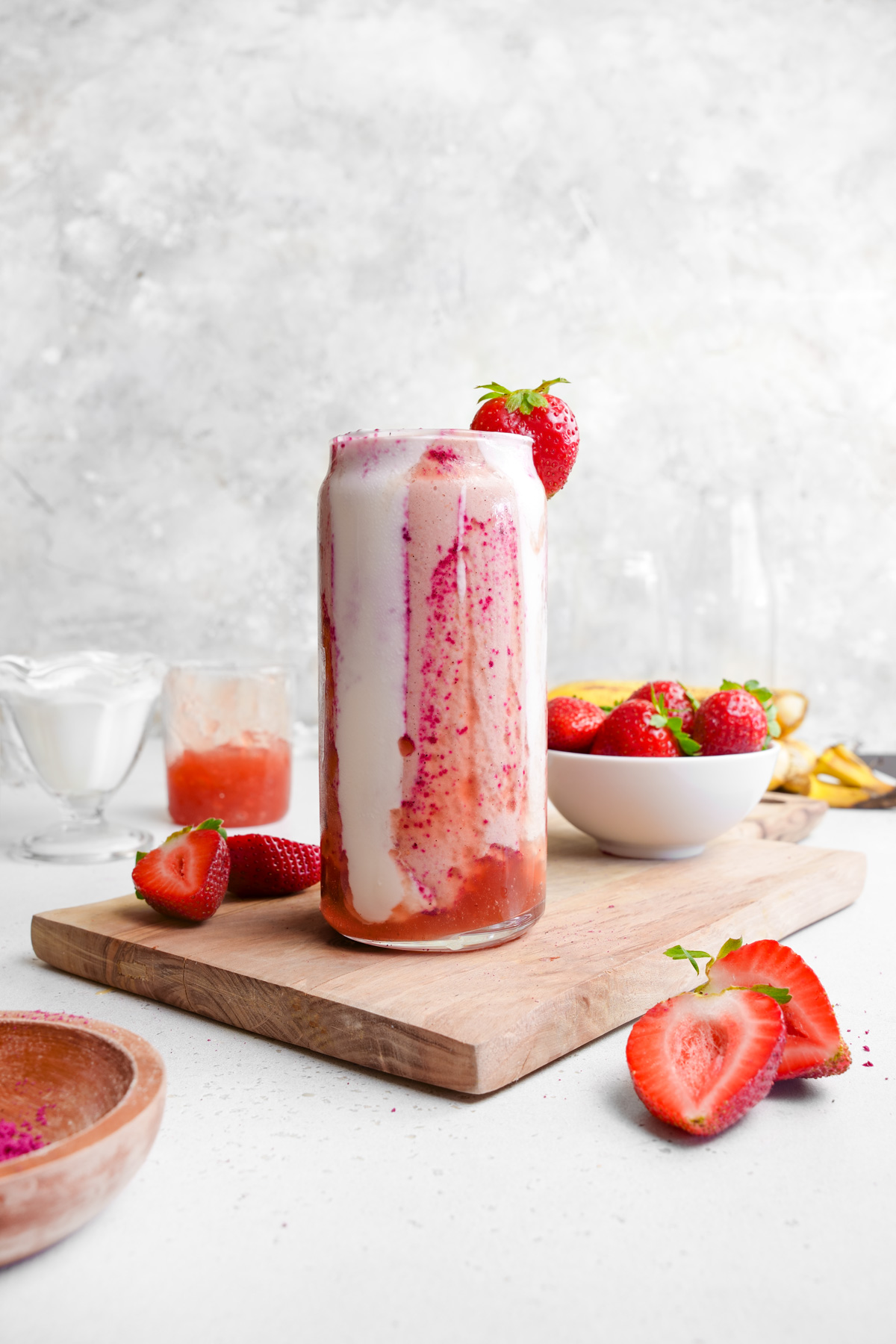 the strawberry glaze smoothie with fresh strawberries and bananas all around it