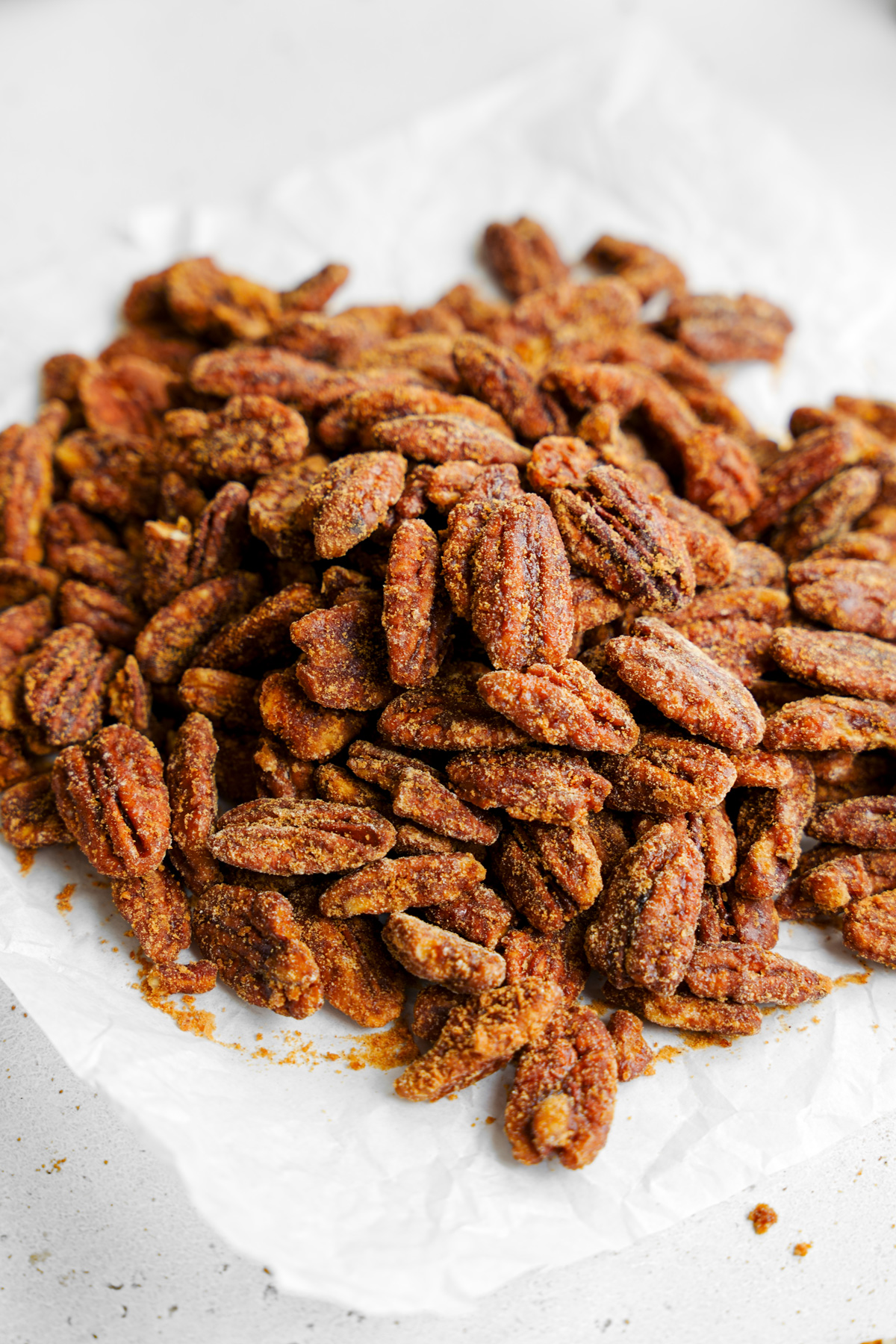 the crunchy healthy candied  pecans on a piece of parchment paper 