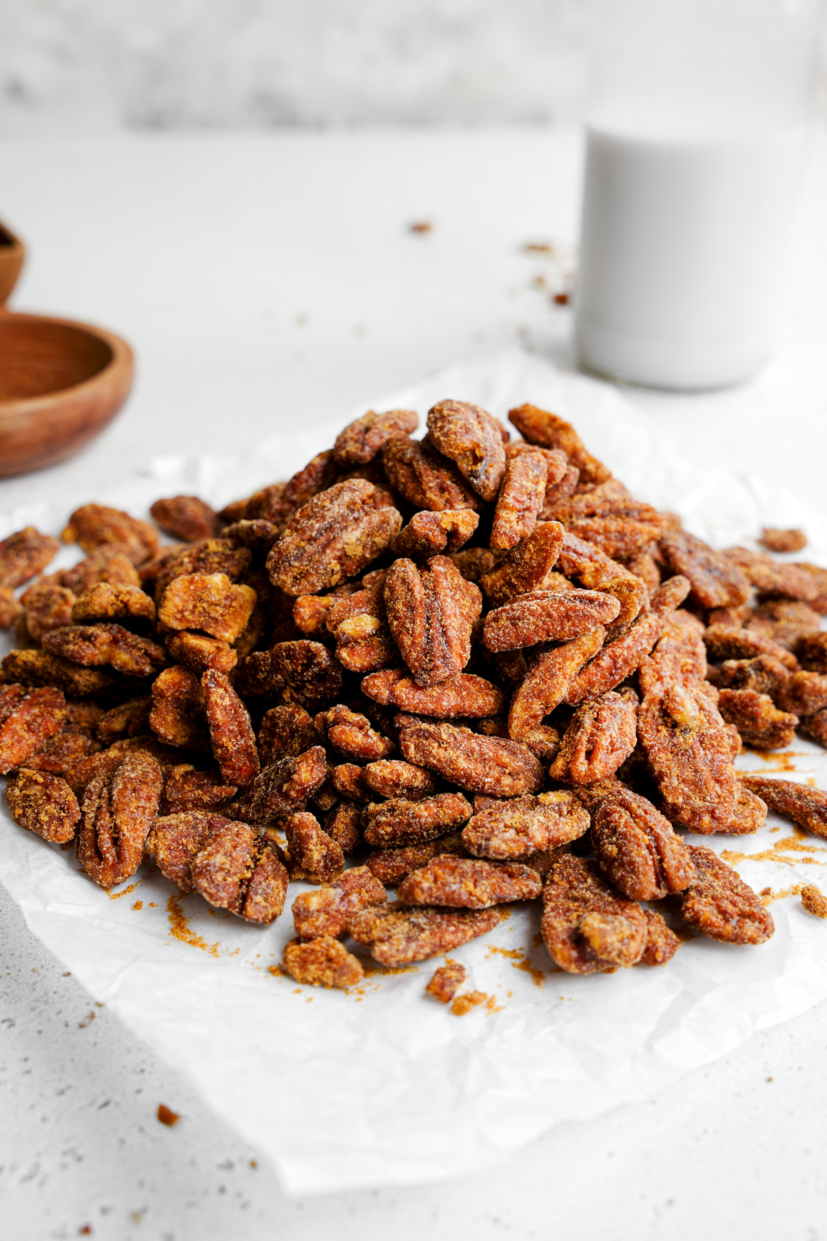 a pile of the healthy candied pecans on a piece of parchment paper