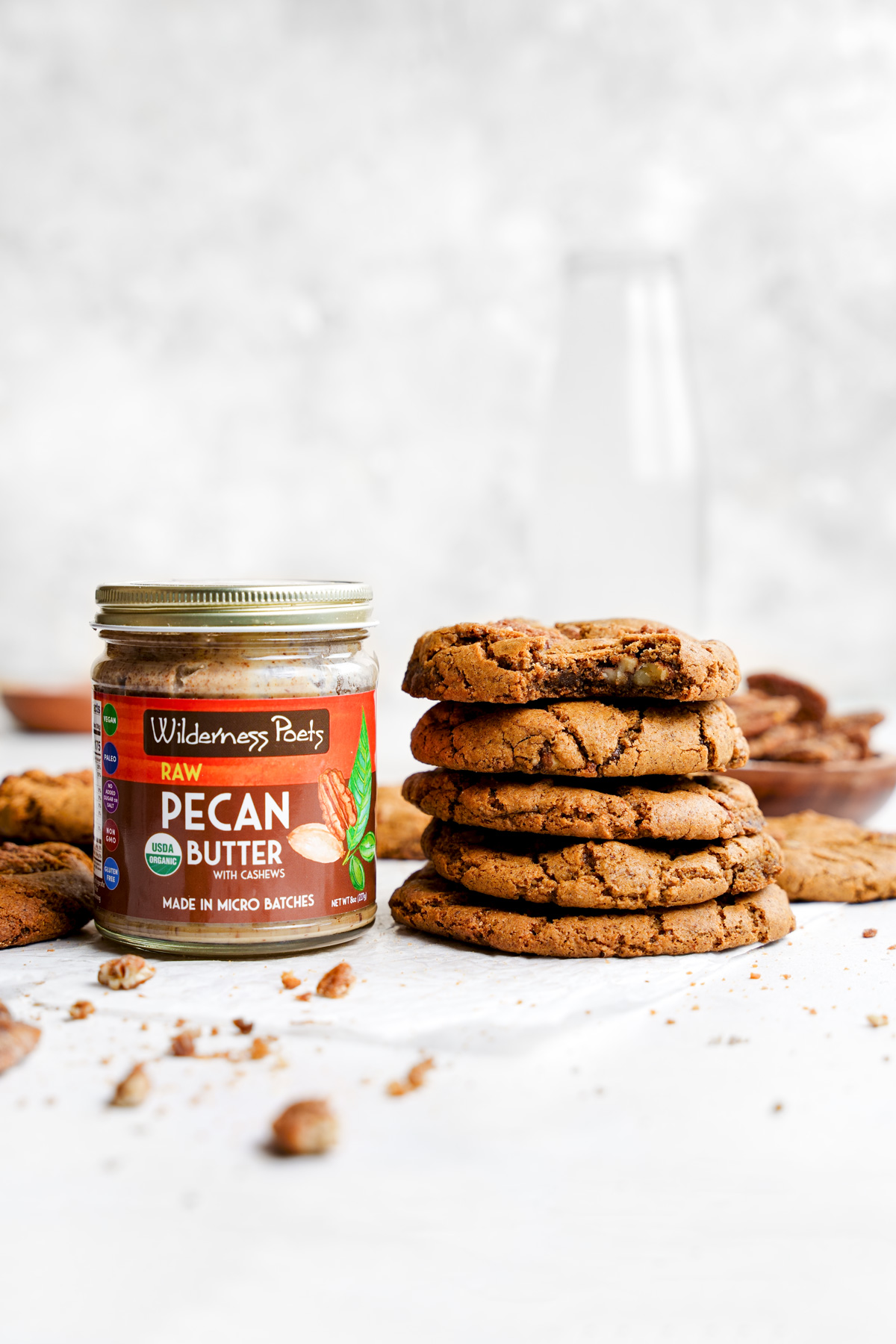the pecan cookies stacked on top of each other next to the wilderness poets pecan butter jar