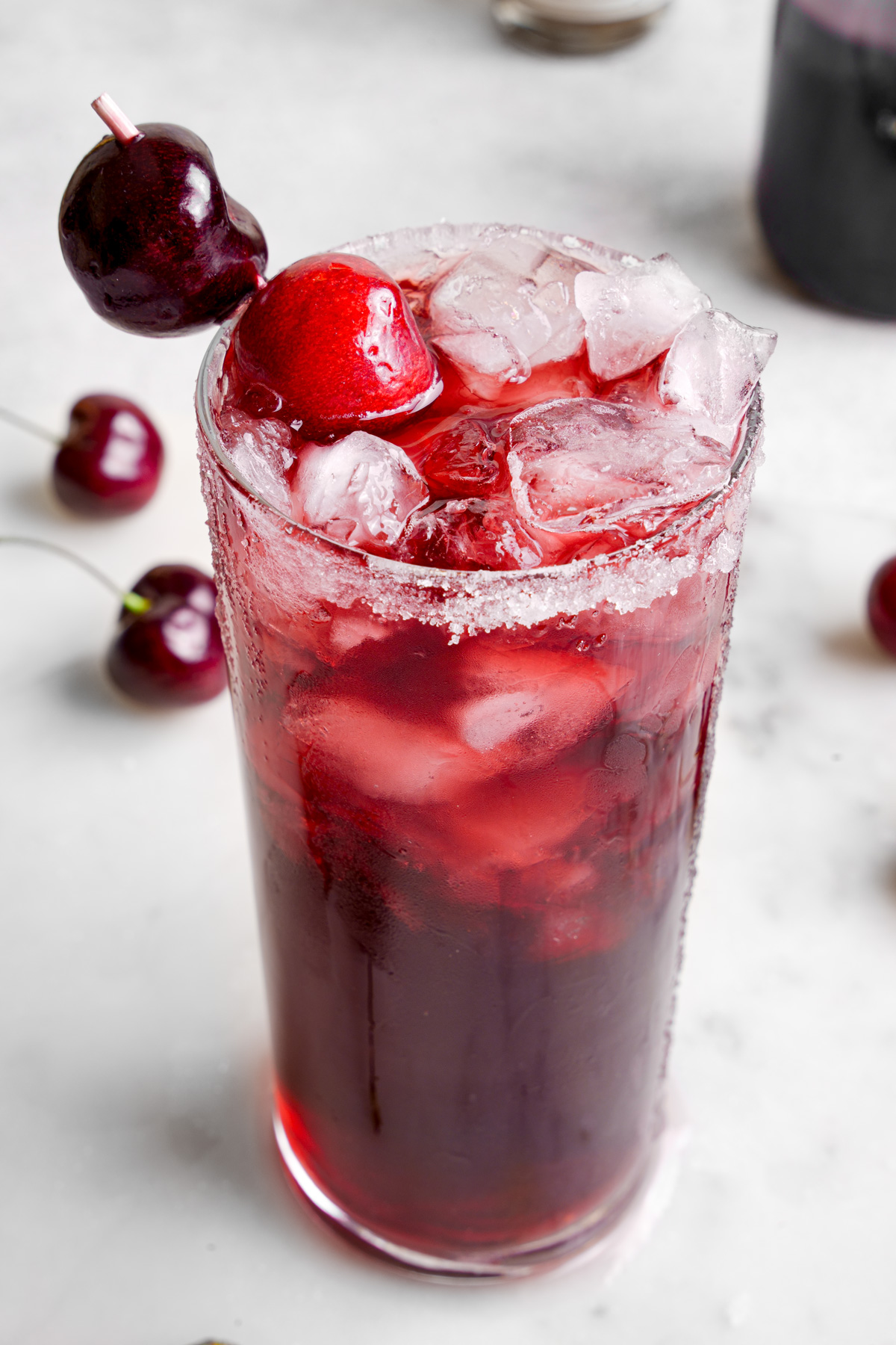 a close up of the sleep mocktail with fresh tart cherries on top