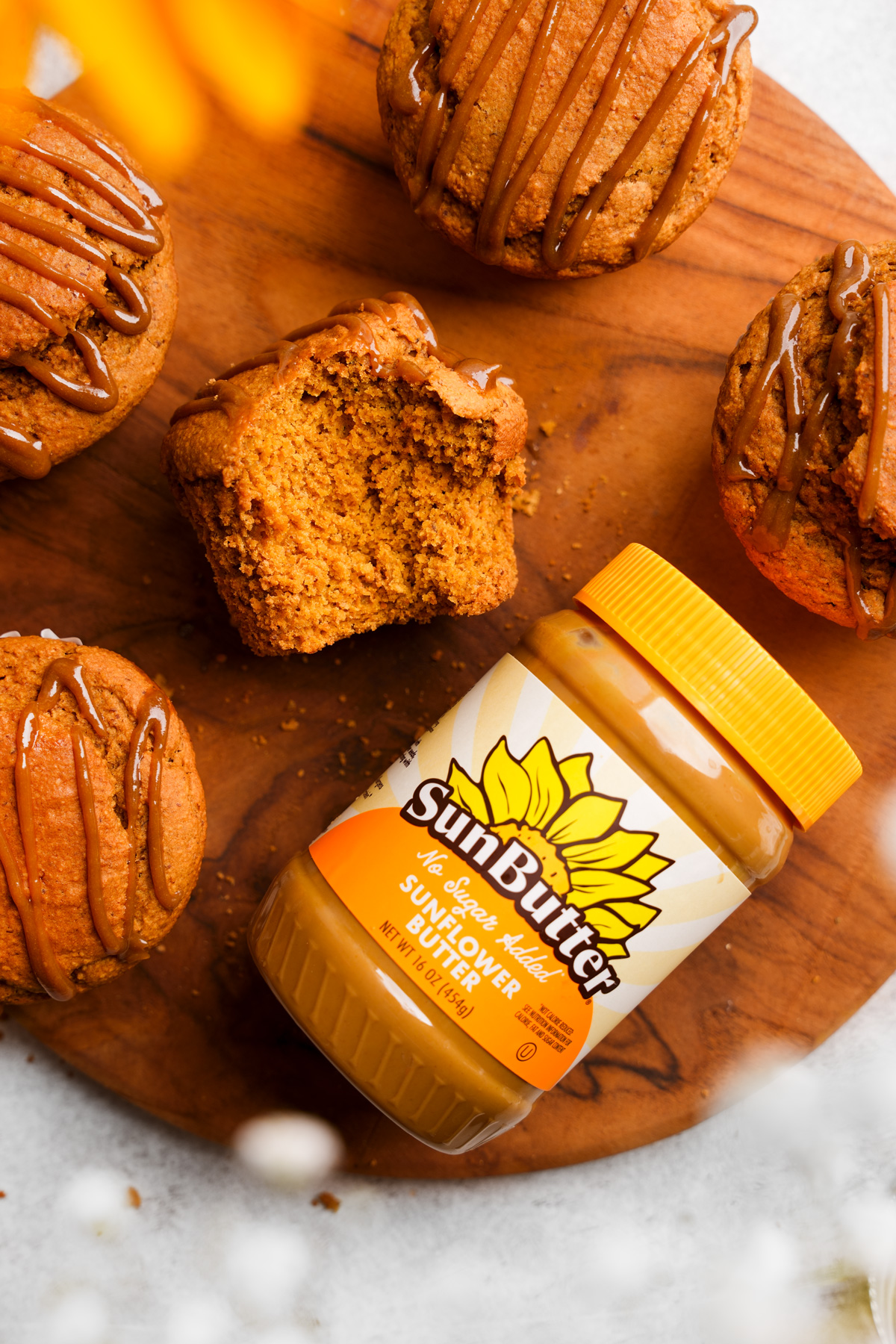 the sunflower seed muffin with a bite out of it next to the sunbutter 