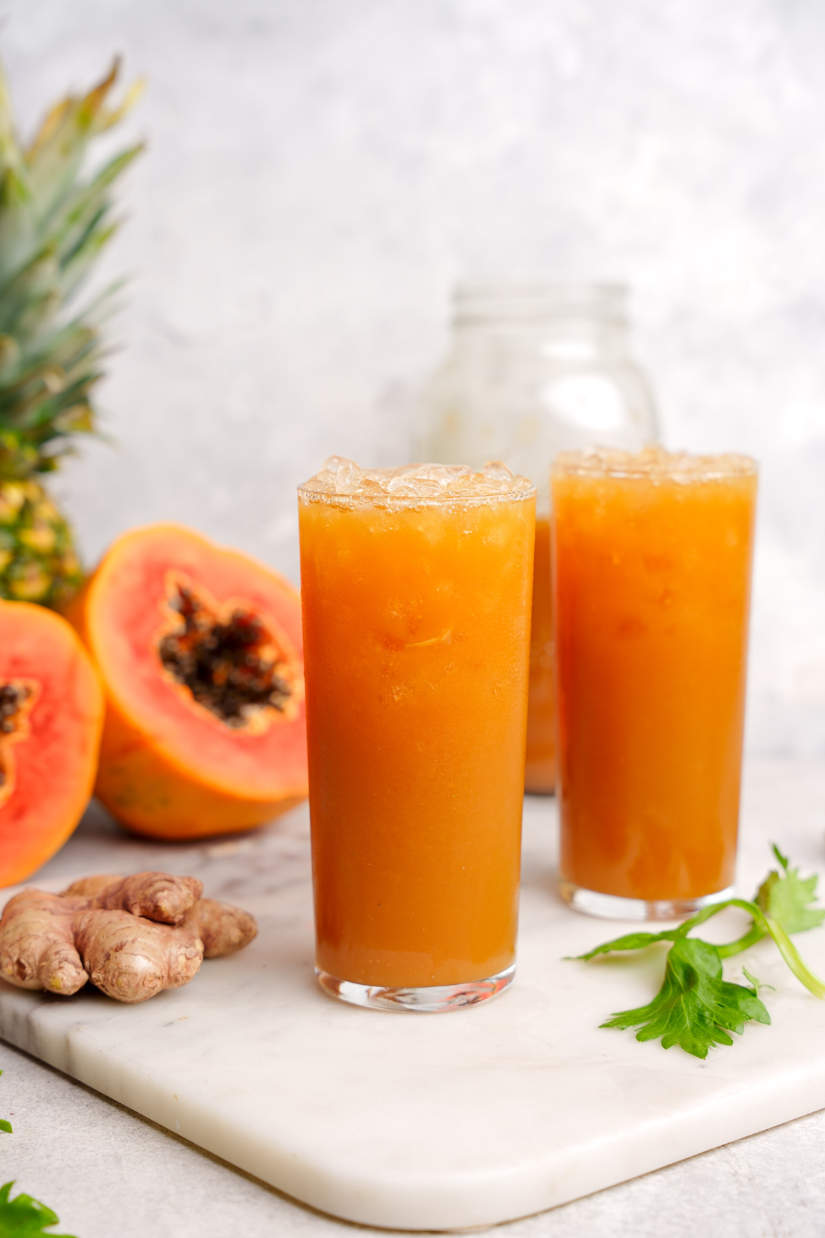 the papaya juice in glasses with fresh papaya in the background