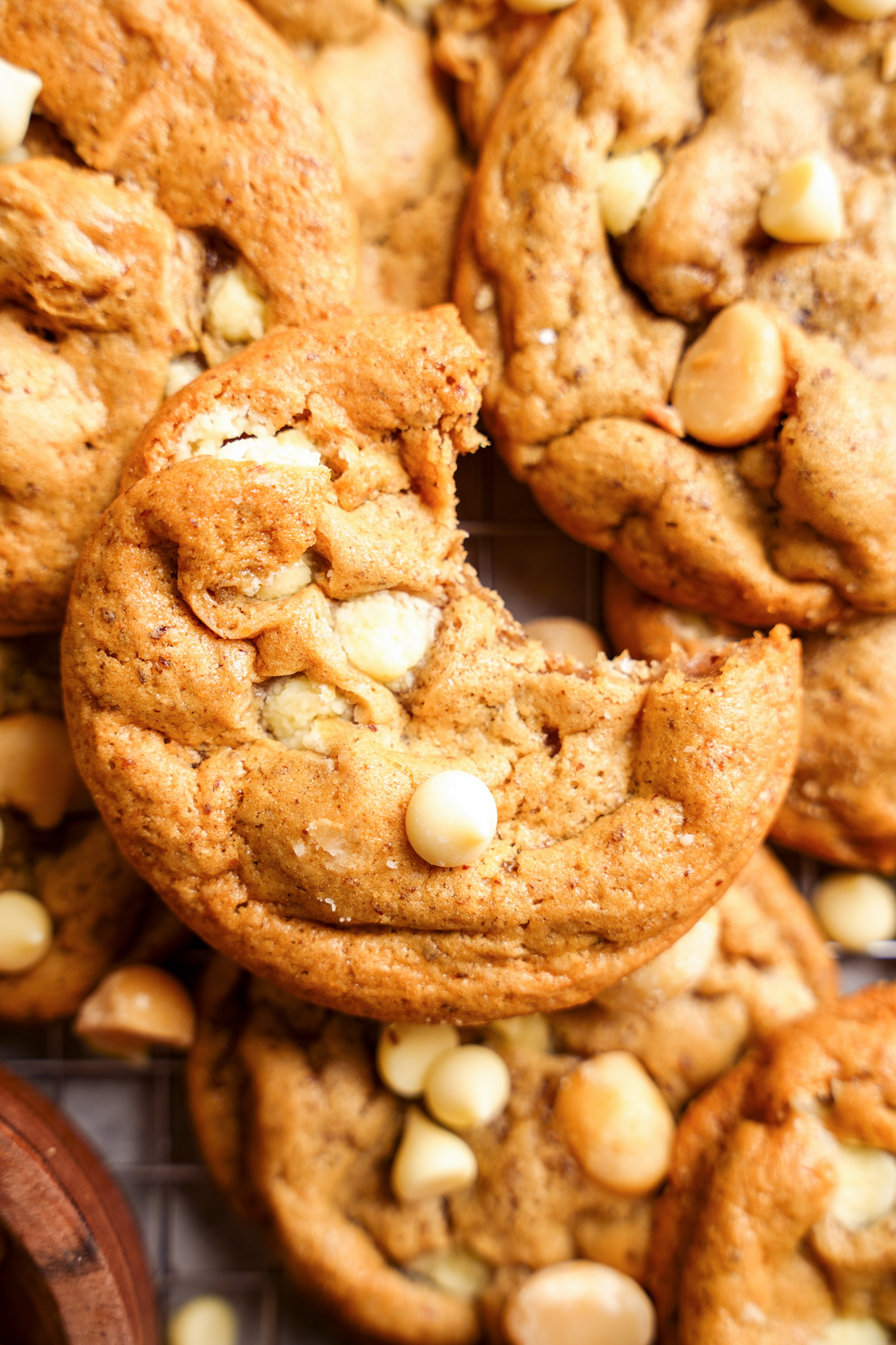 one of the white chocolate macadamia nut cookies with a bite taken out of it