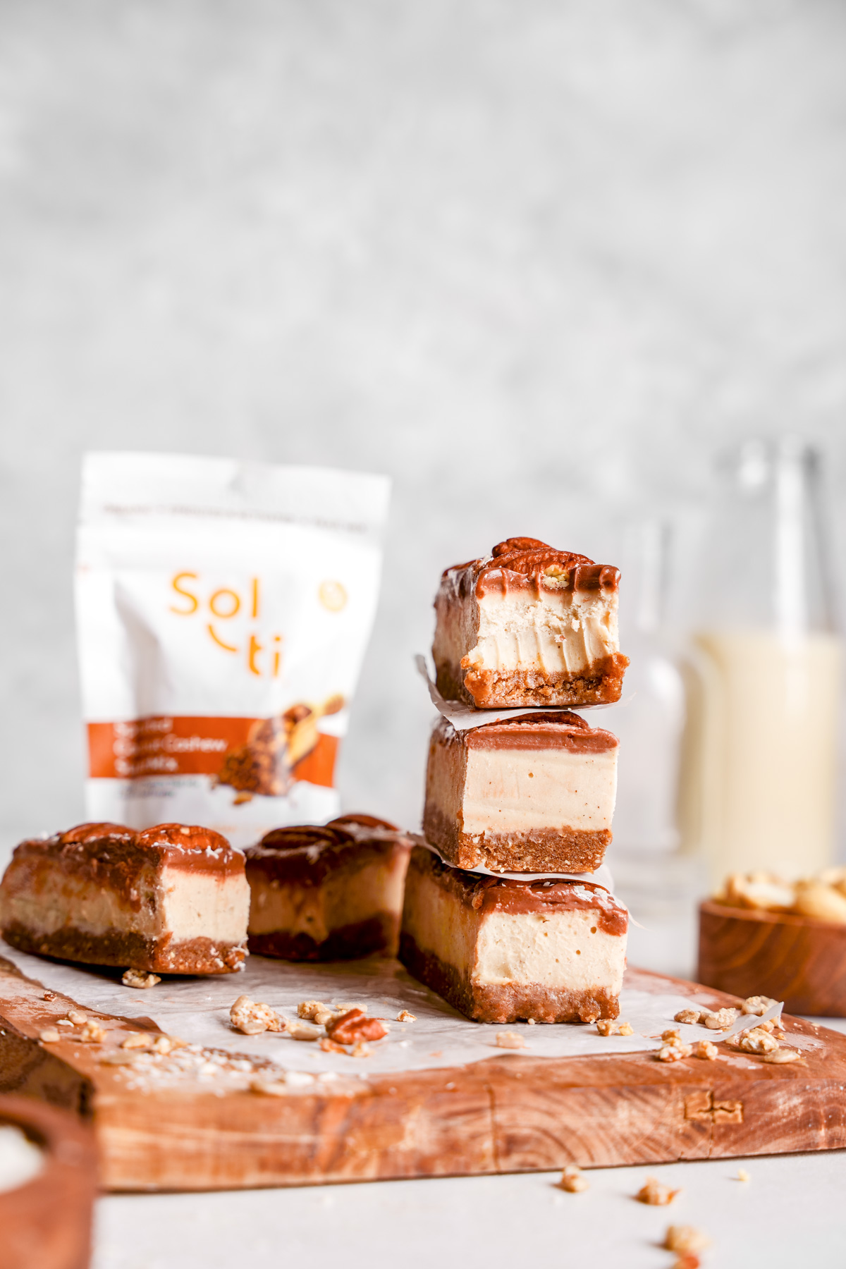 the raw vegan pecan bars stacked on top of each other with the sol-ti supermix bag