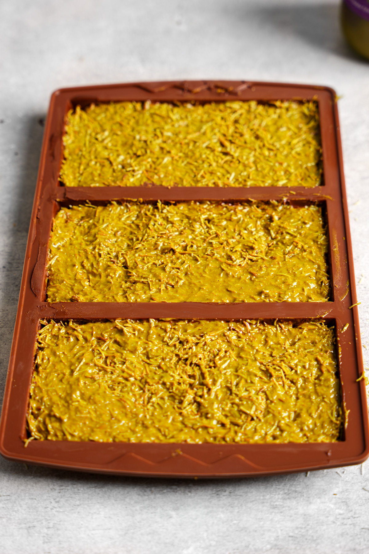adding the pistachio filling to the chocolate molds