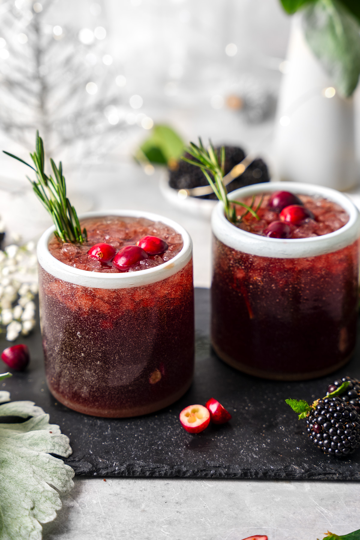 the healthy cranberry mocktail in glasses with fresh produce as the garnishes