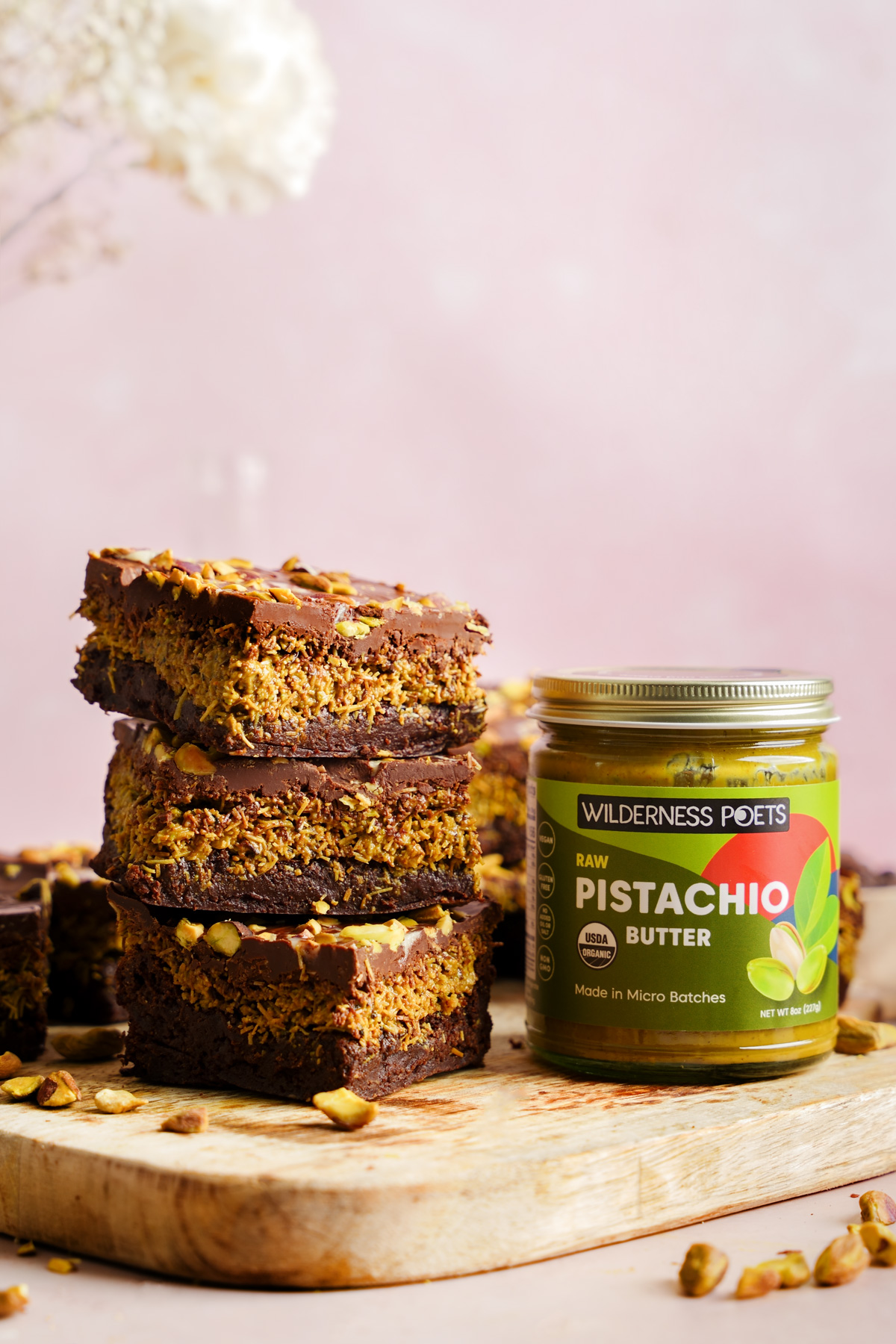 the dubai chocolate brownies stacked on top of each other with the wilderness pots pistachio butter next to them