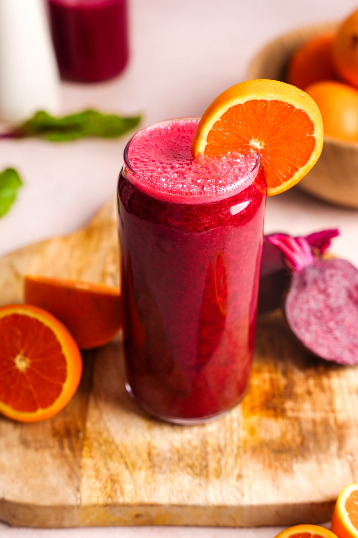 the beet carrot juice in a glass topped with an orange slice