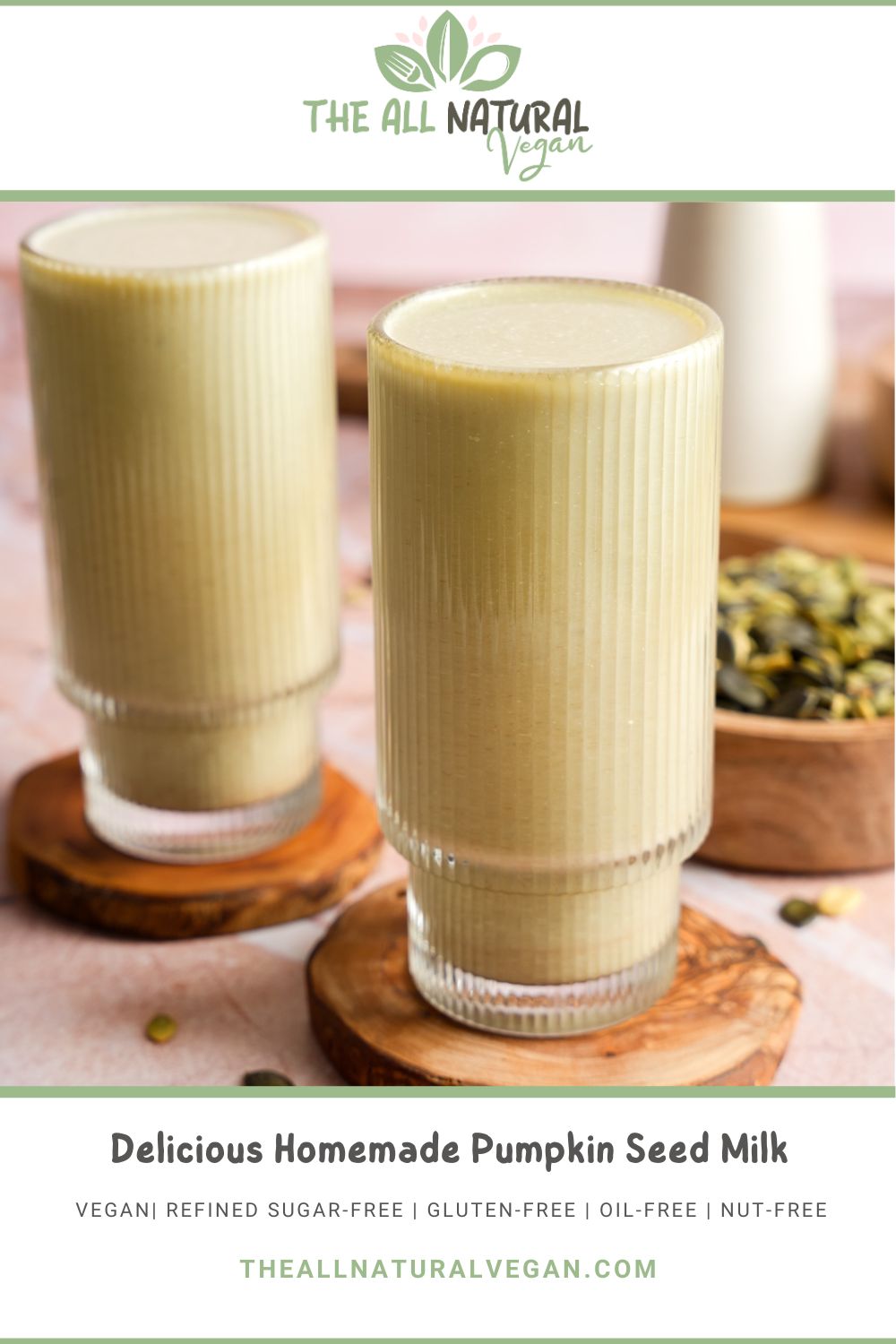 Glass of creamy homemade pumpkin seed milk on a wooden coaster, with pumpkin seeds and a bowl of seeds in the background, styled for The All Natural Vegan recipe graphic.